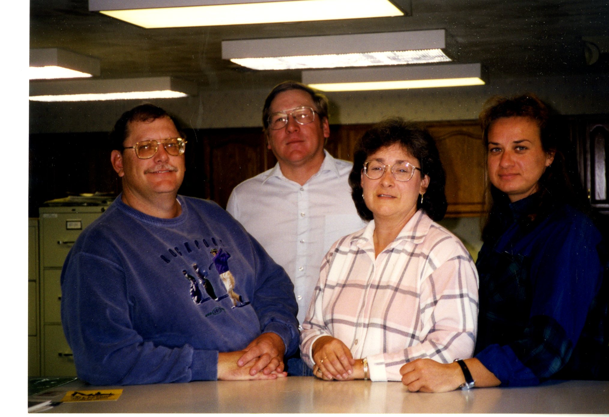 Four People Standing at Service Center Counter