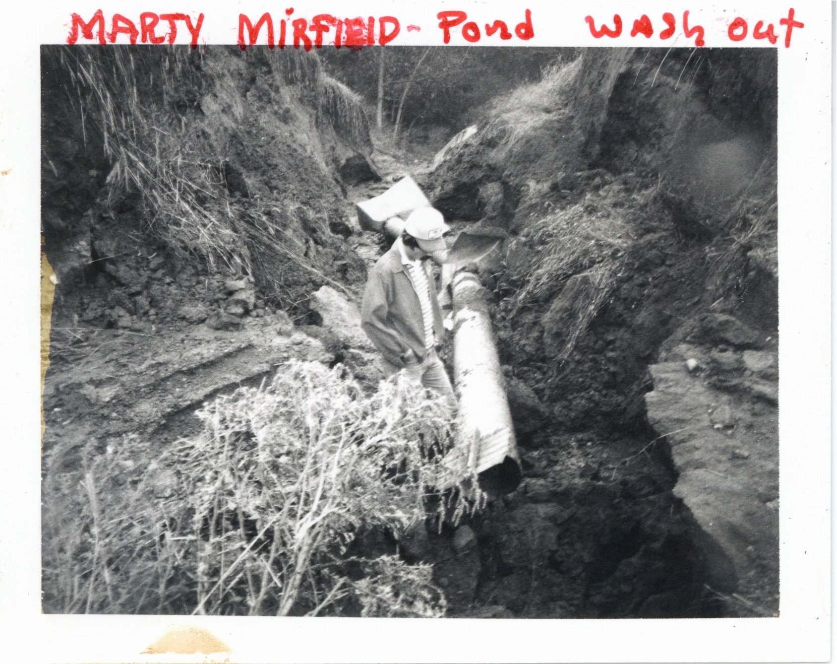 Marty Mirfield looking at pond washout, 1980