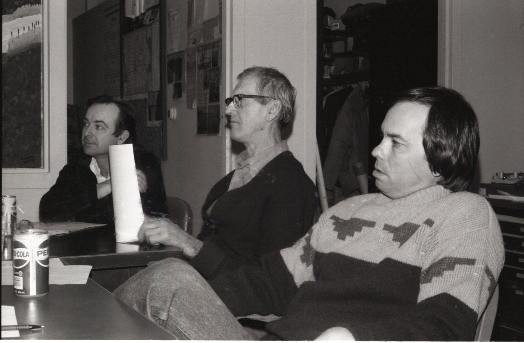 Three men sit at table at meeting