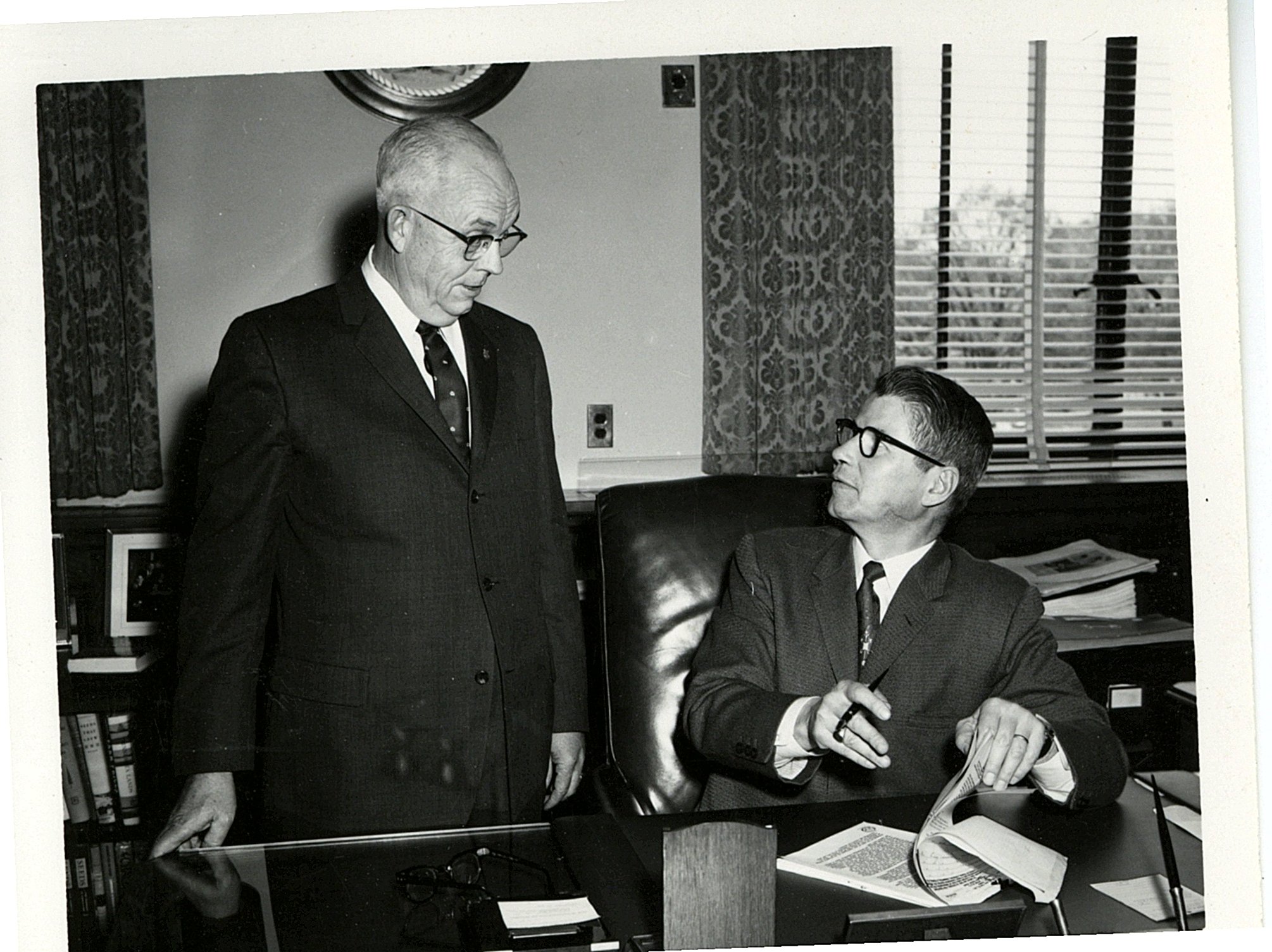 Men conversing over document