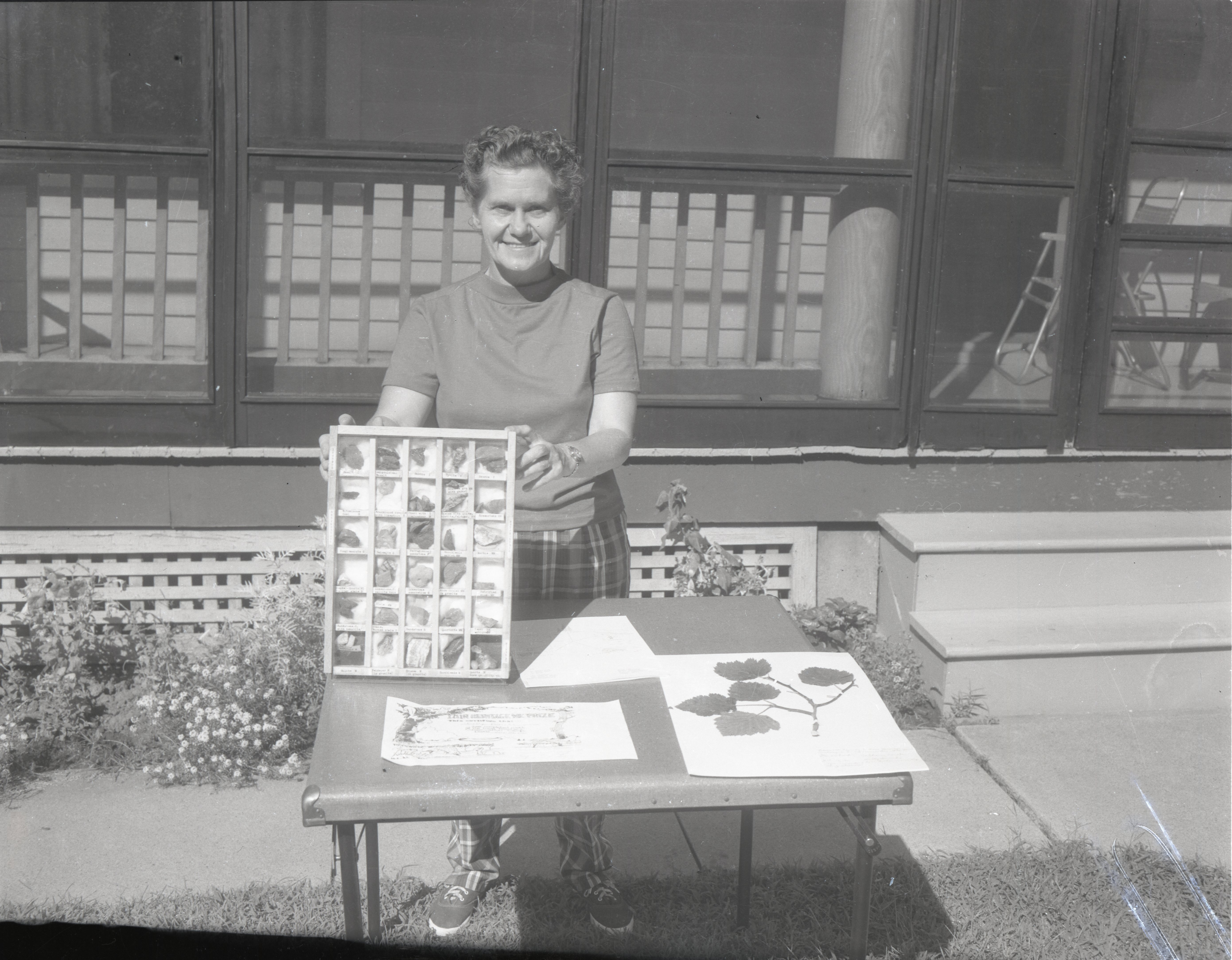 Unidentified woman shows rock samples in tray
