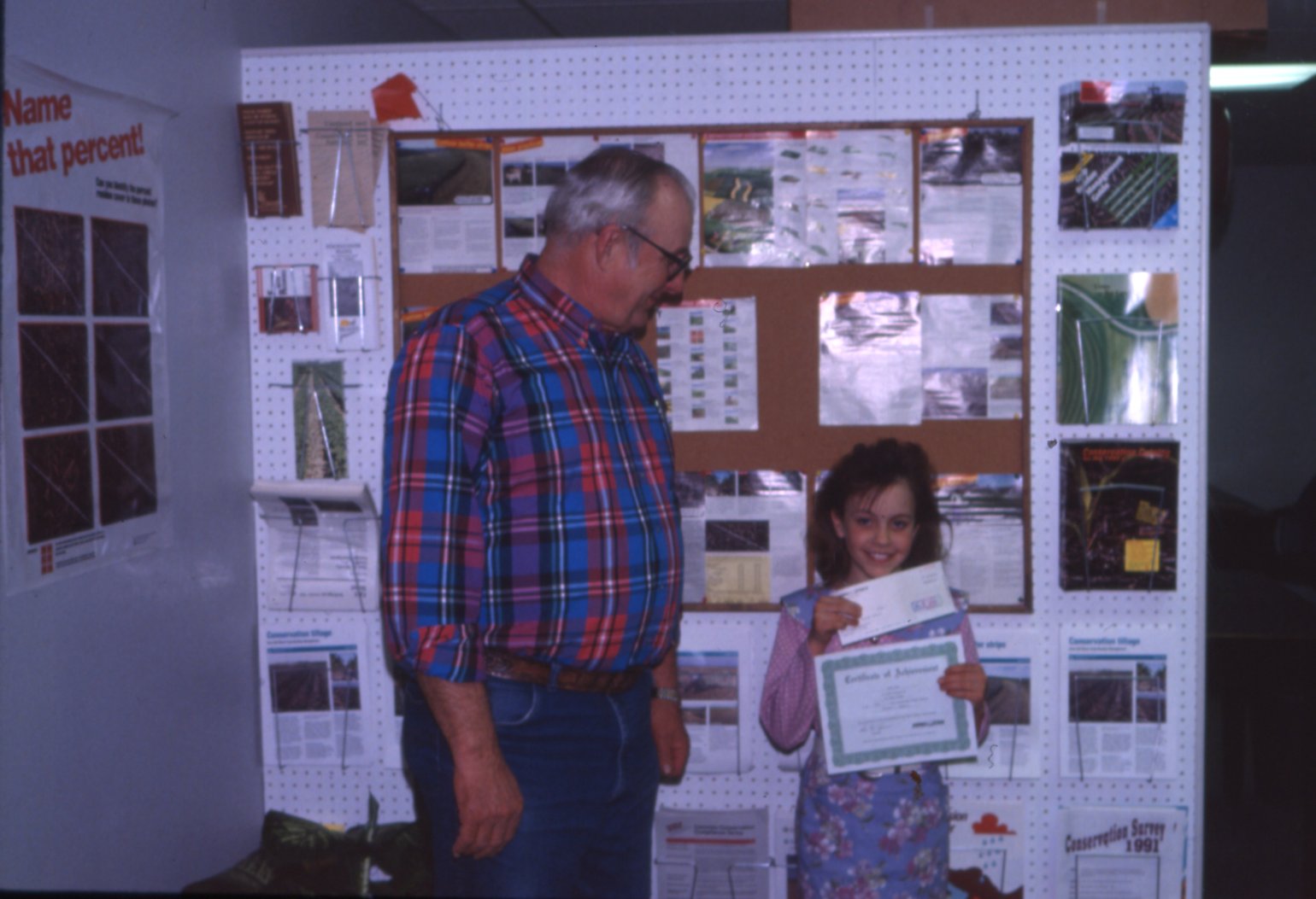 Youth holding award certificate and check