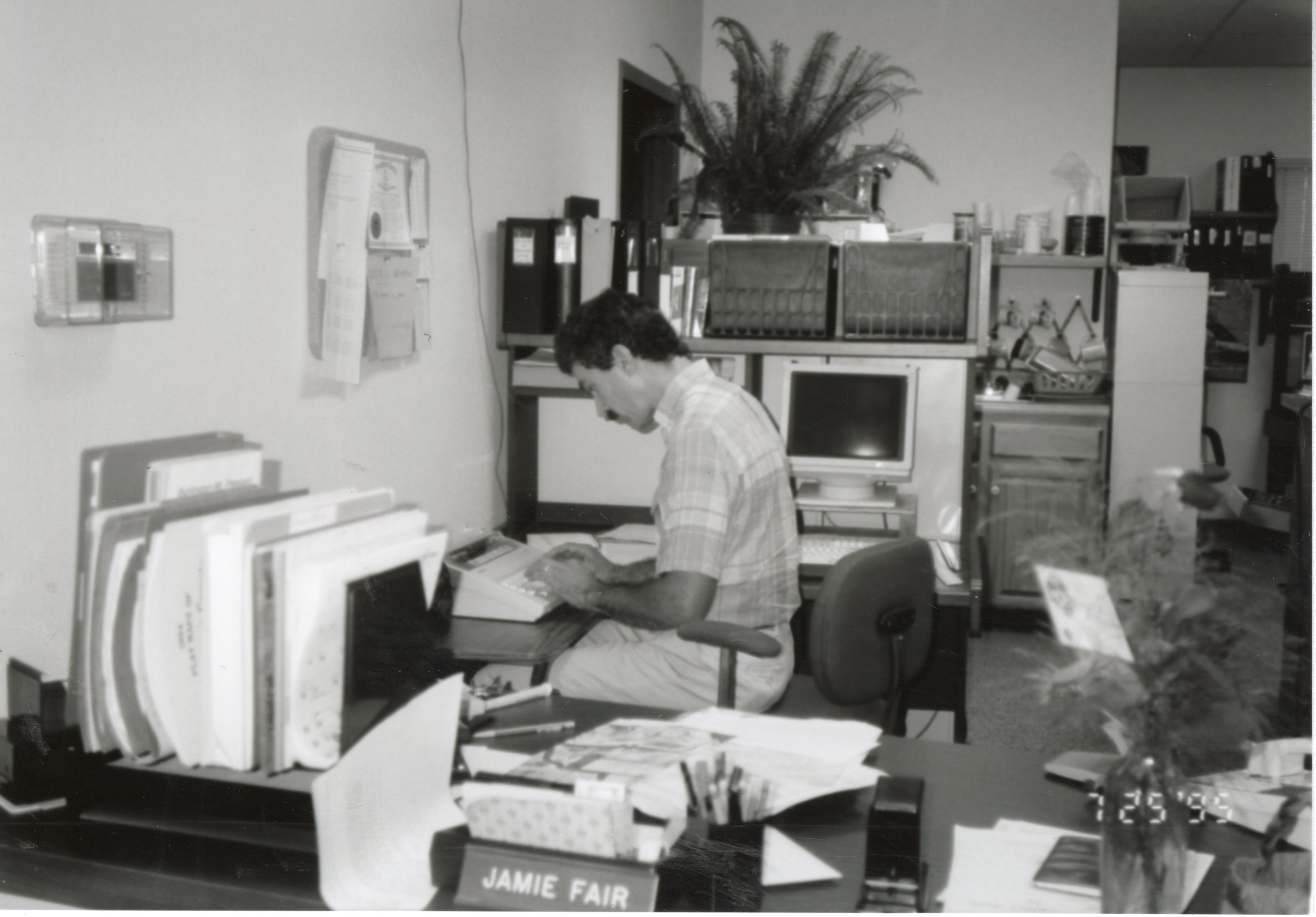 1995 Mike Lewitke, District Conservationist, is typing at a desk.
