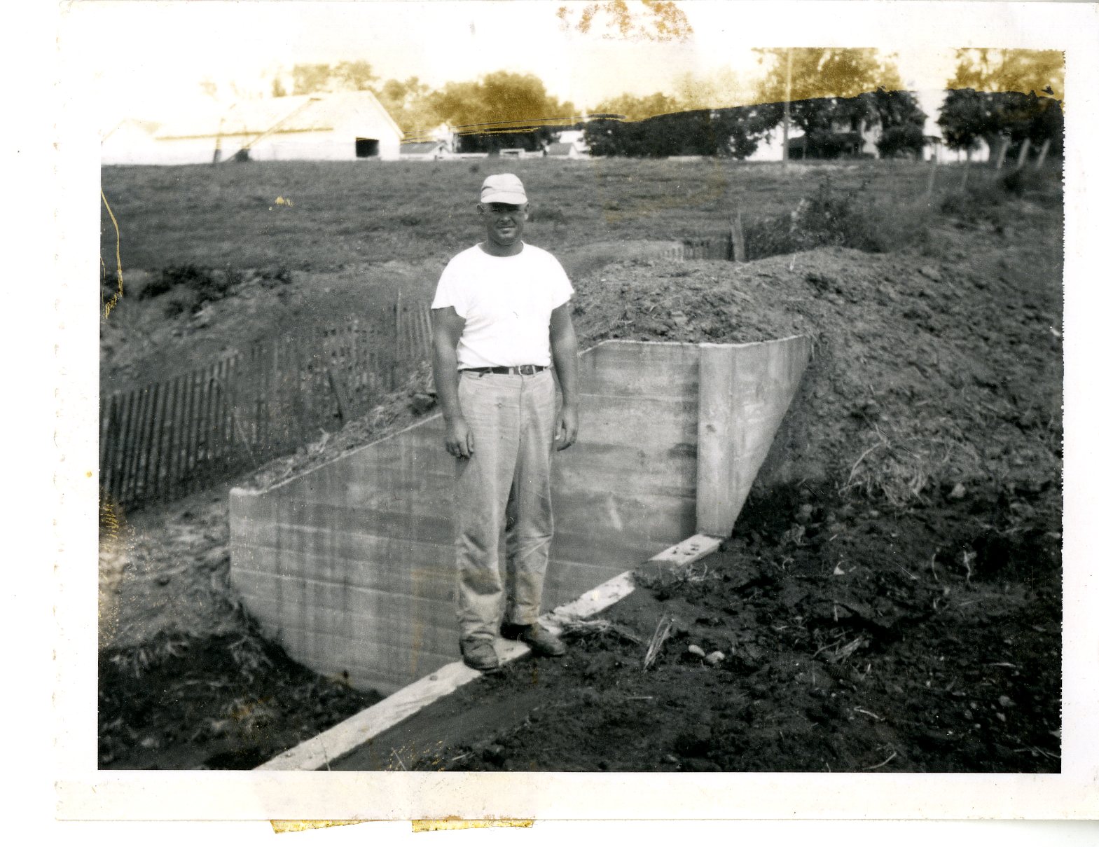 W. Carter standing on Langwith farm drop spillway, 1958