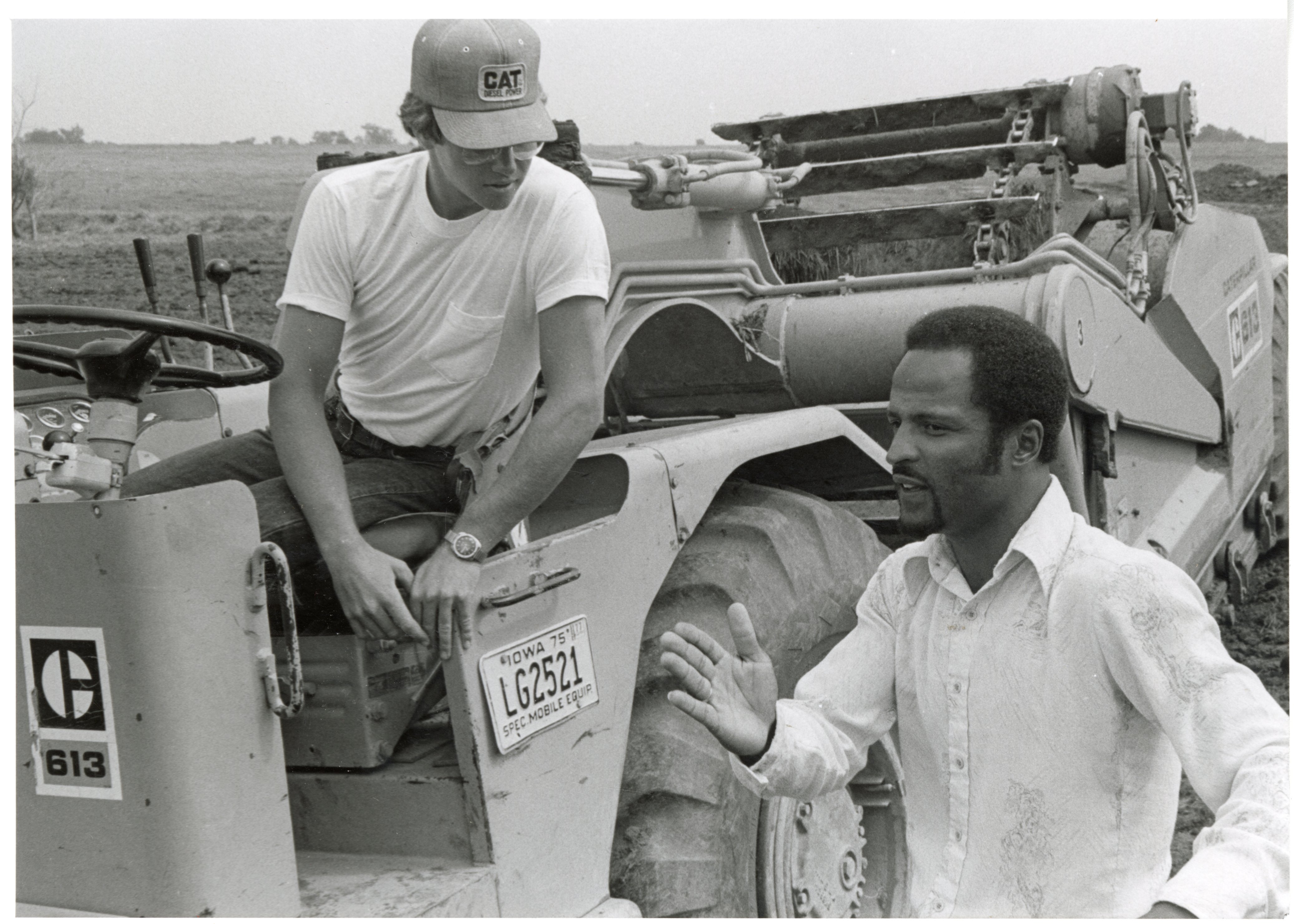 1979  Soil conservation technician talks to man on Caterpillar 613 earthmoving machine