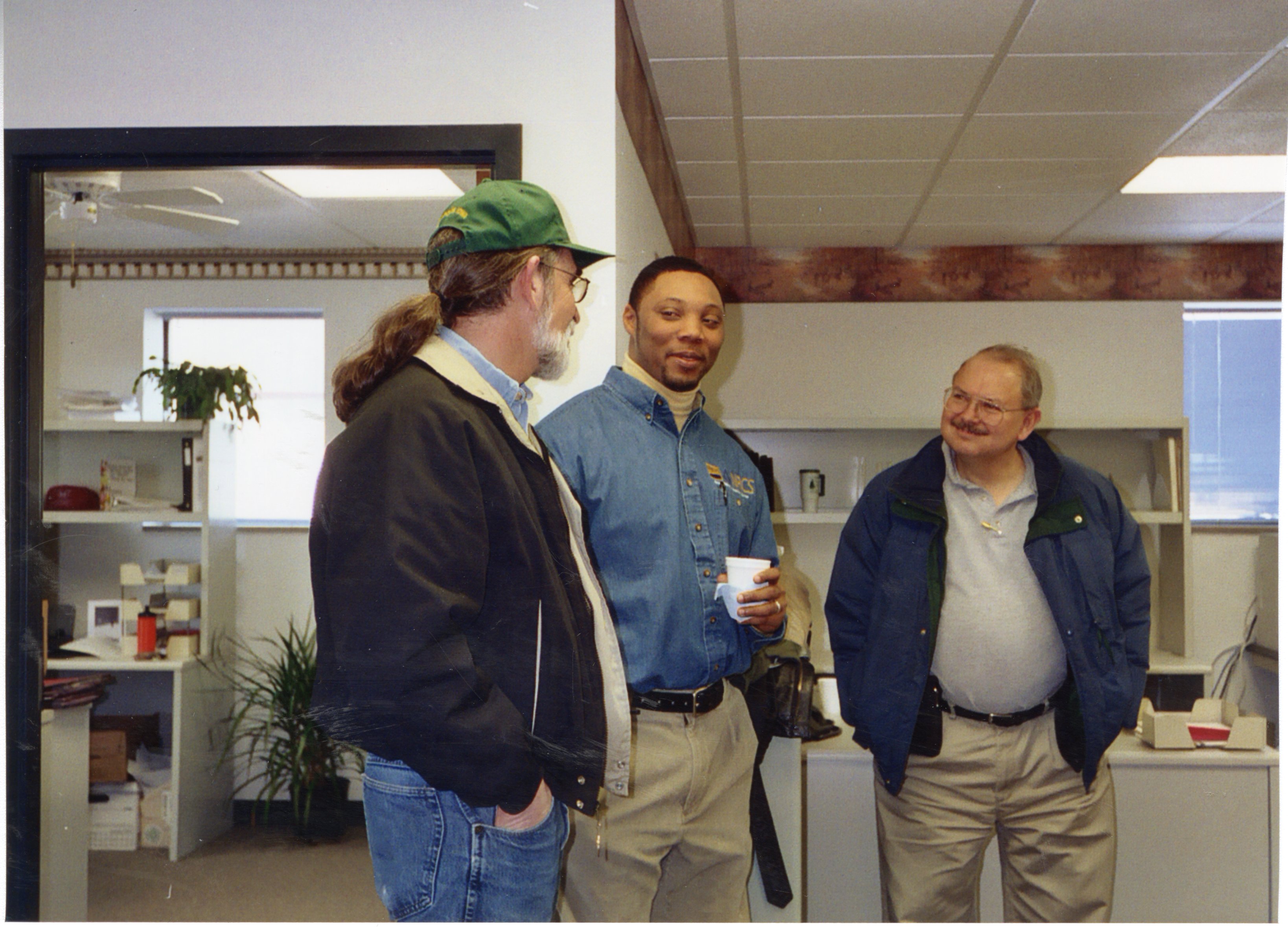 2003  Gerald Fosdick, NRCS District Conservationist Terrance Rudolph, and Extension Director Don Buzzingham chat in the office
