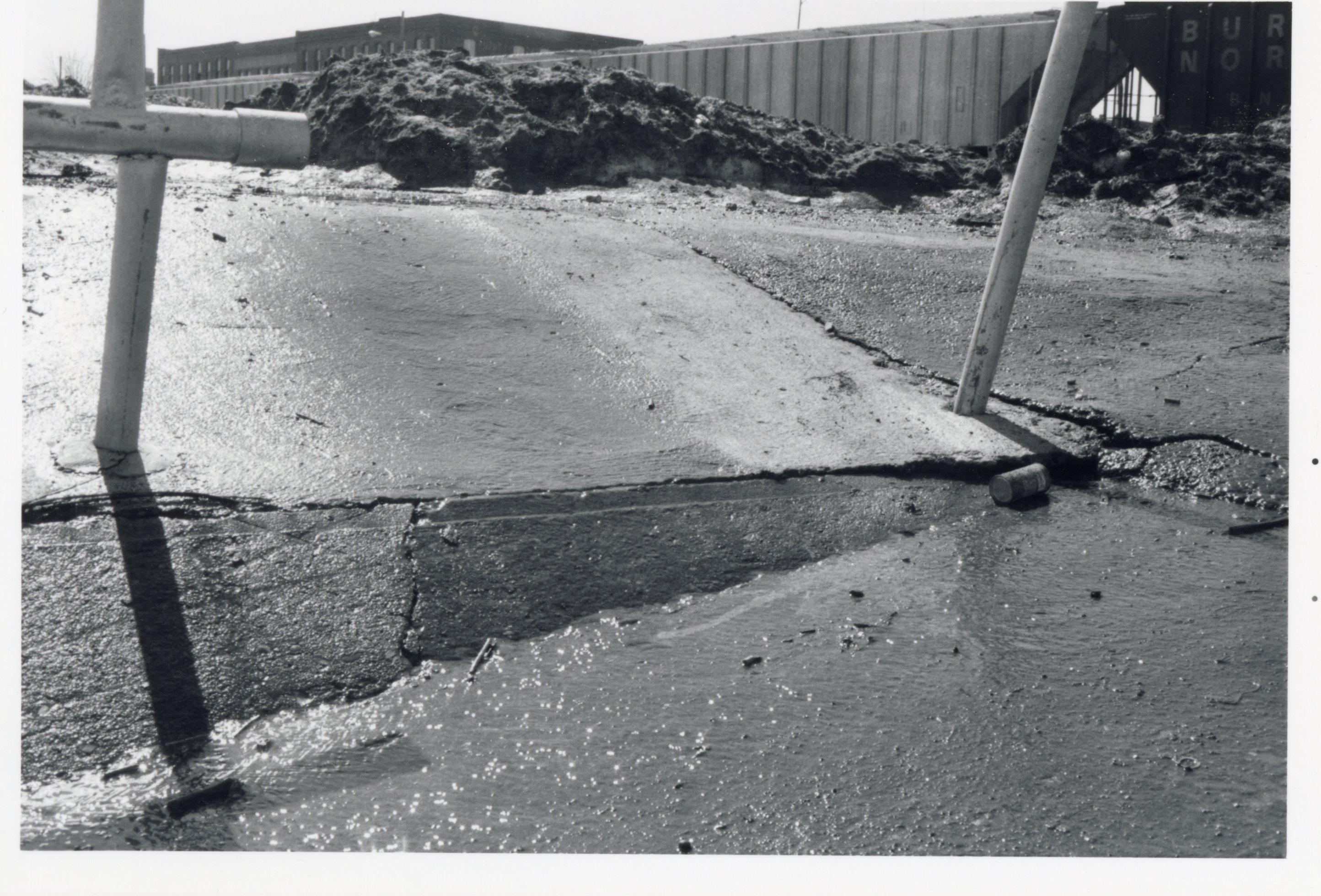 Uneven pavement in front of dirt pile