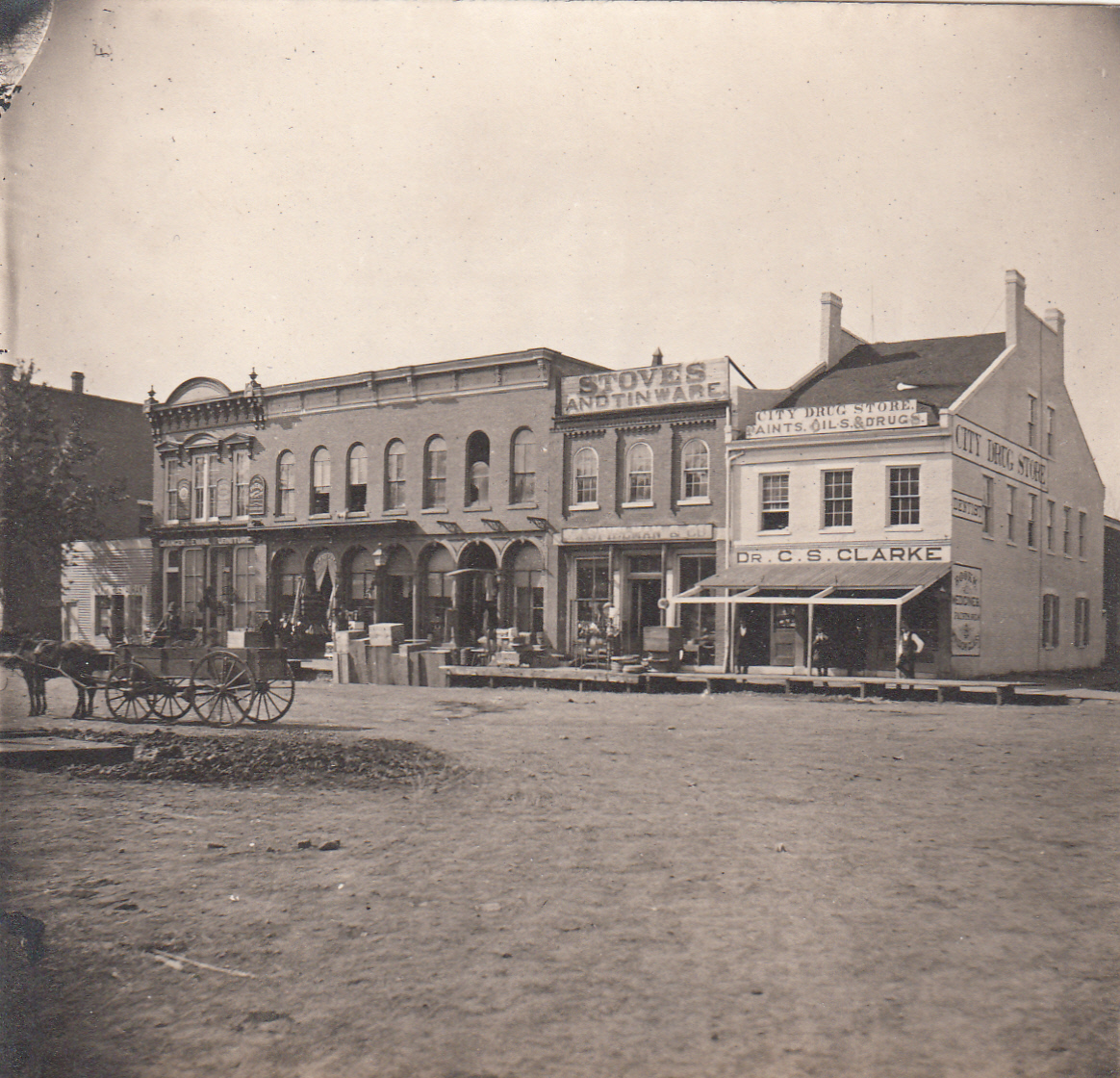 0126 West side of square with stores and a horse and wagon in the street