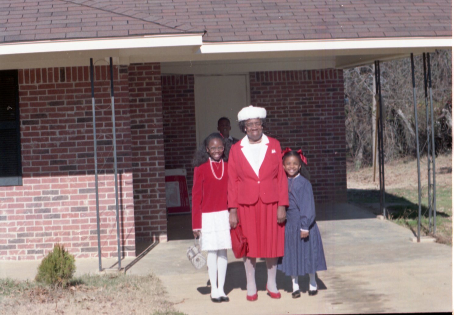 Unidentified family dressed up stands in front of brick building