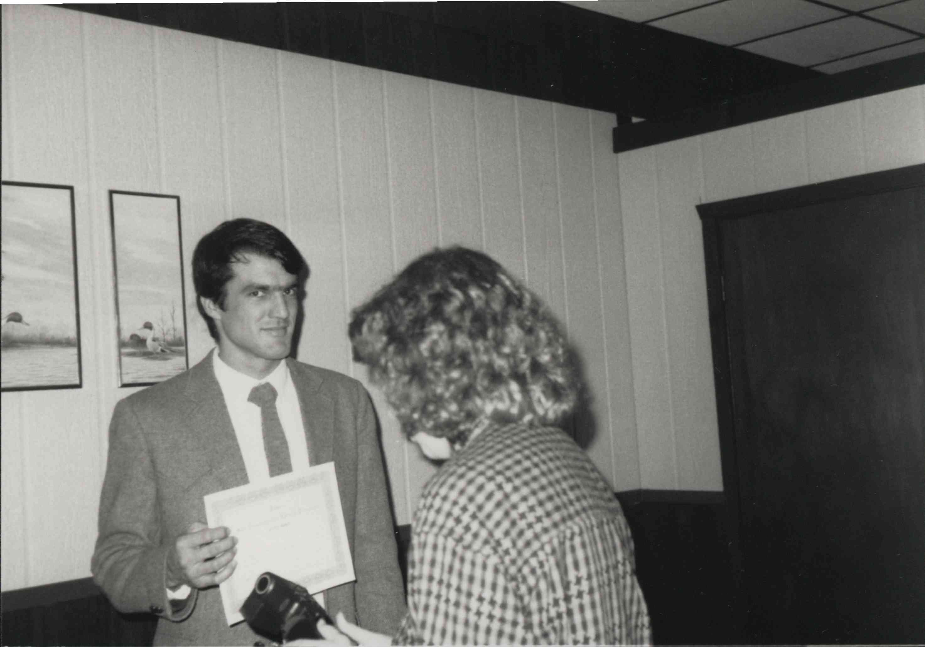 Office Photo with Man Holding Certificate