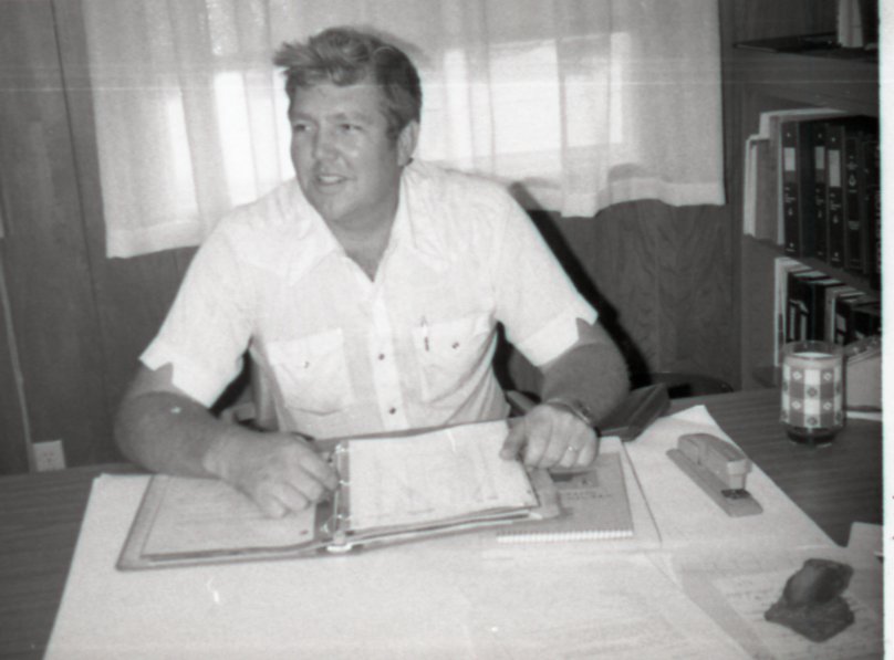 Unidentified Man Sits at Desk with Notebook