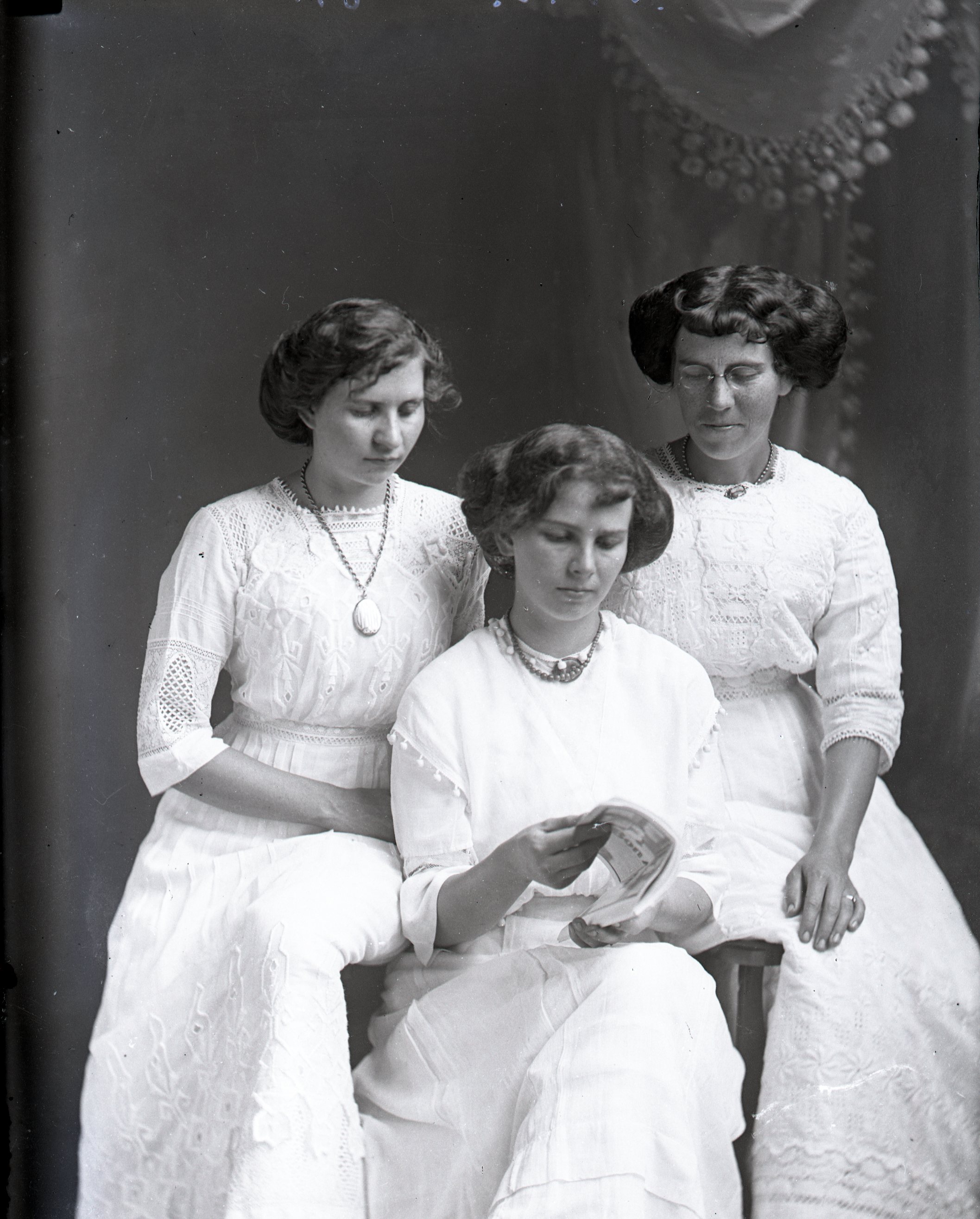 Three women reading a letter