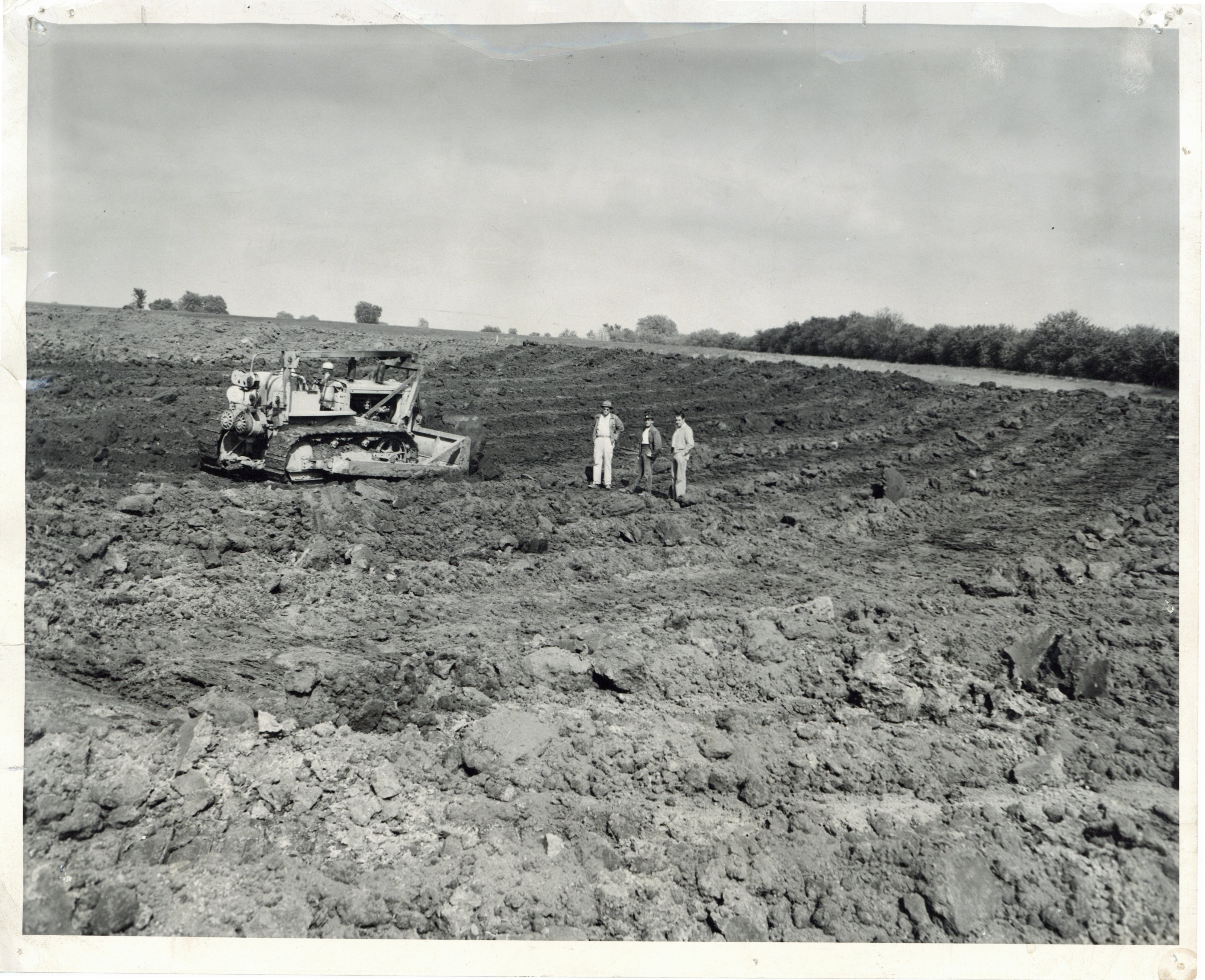 Men in bulldozed field