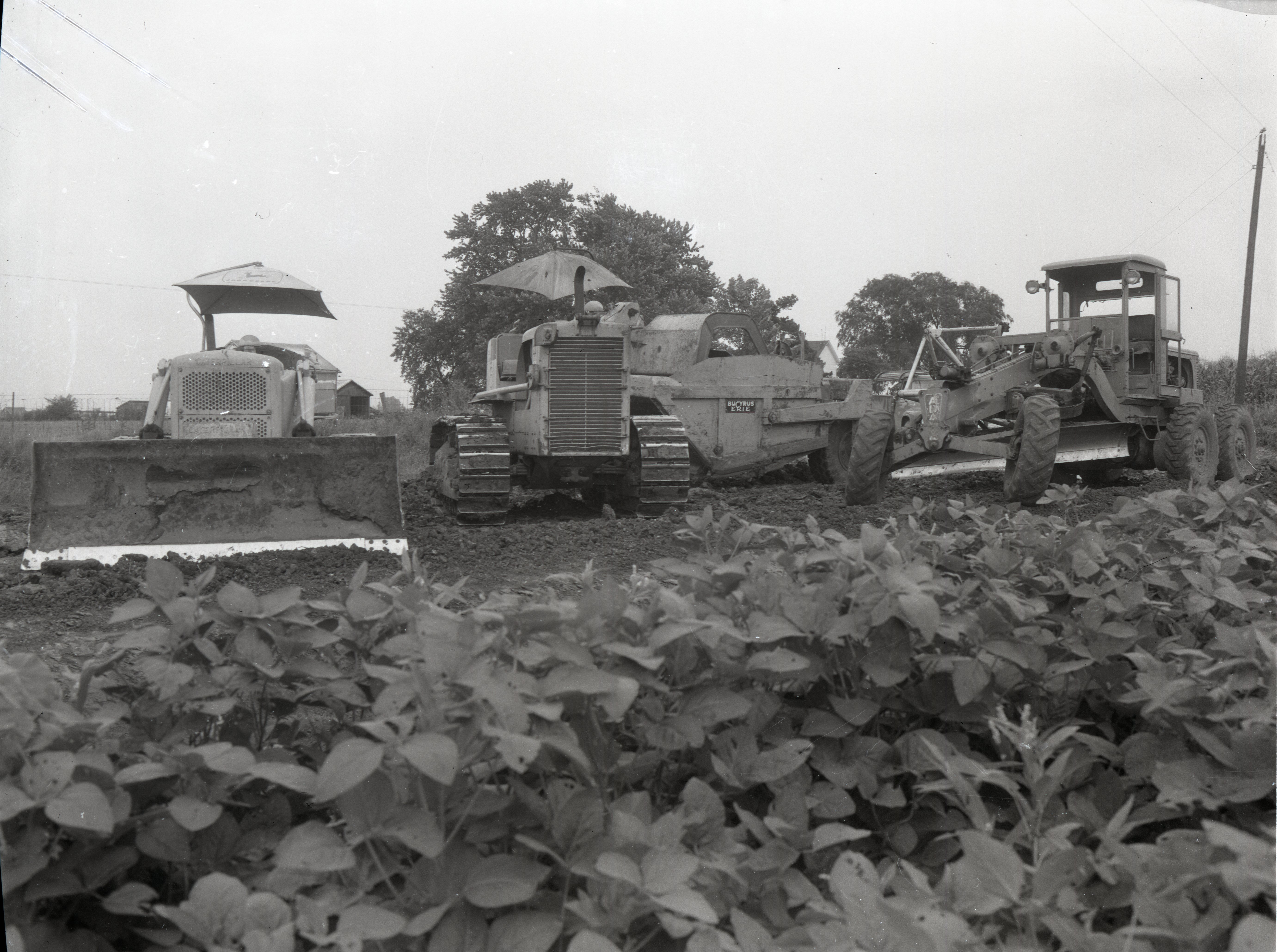 Three Pieces of Farm Machinery Stand in a Row