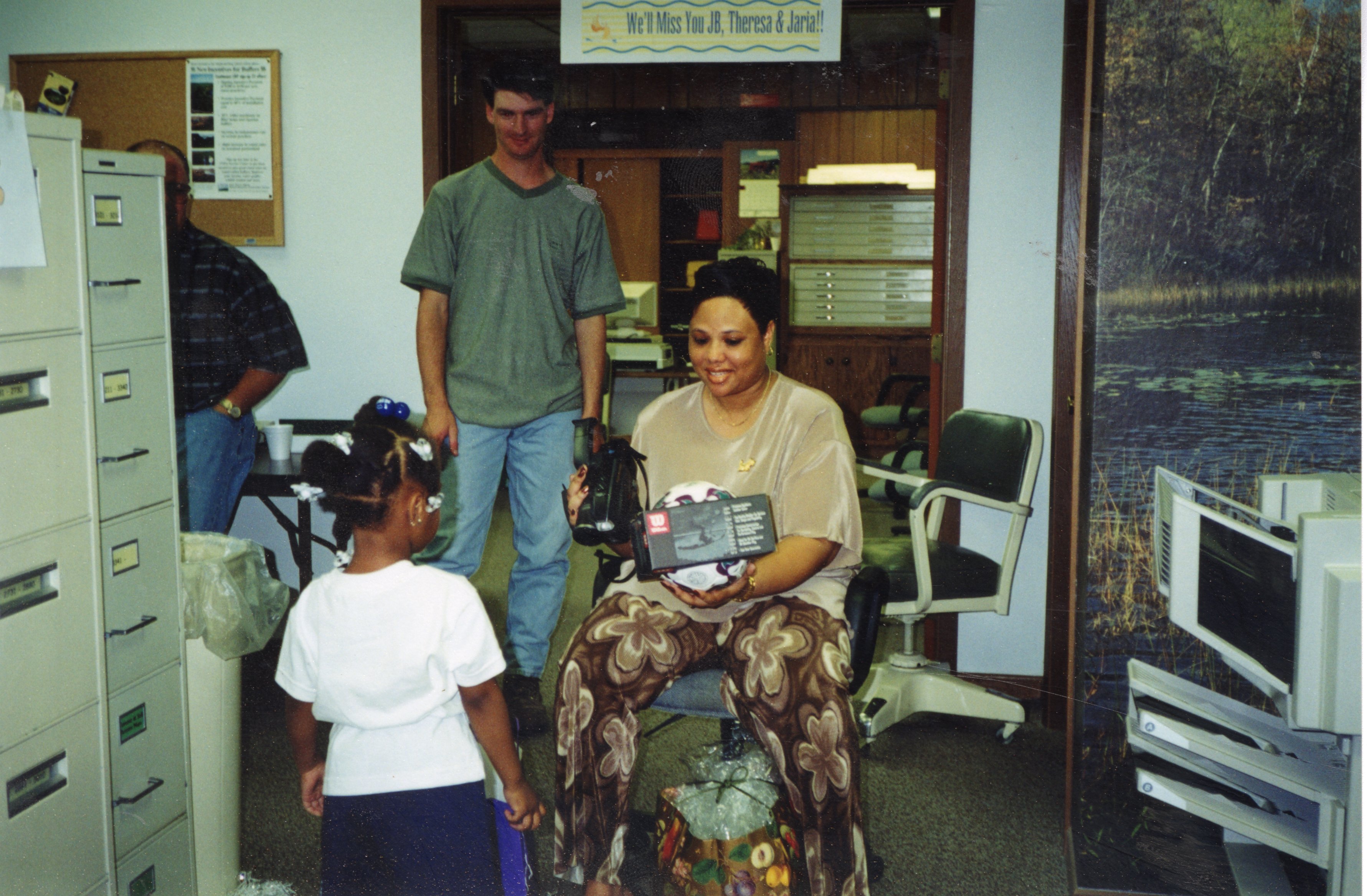 2000  Soil Conservation Aide Chris Hogge watches as Theresa Martin and her daughter Jaria, open a package