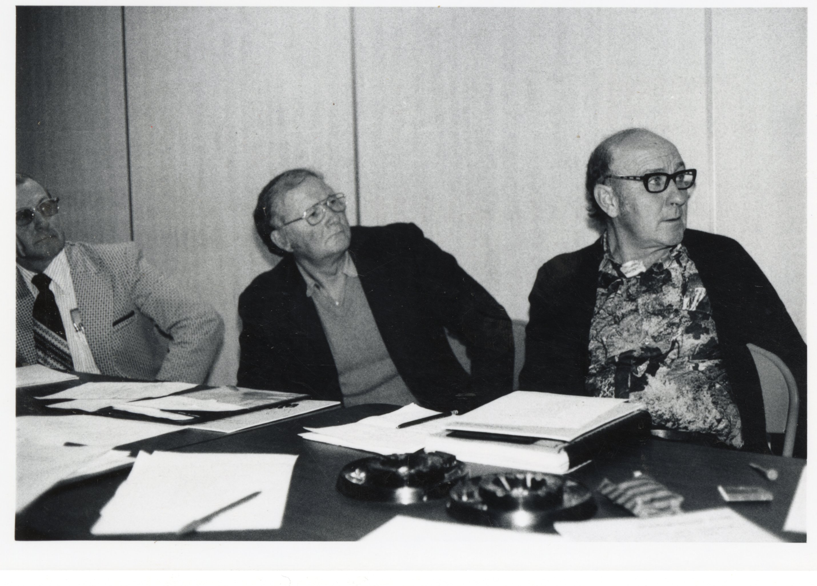 Three unidentified people at unidentified meetings
