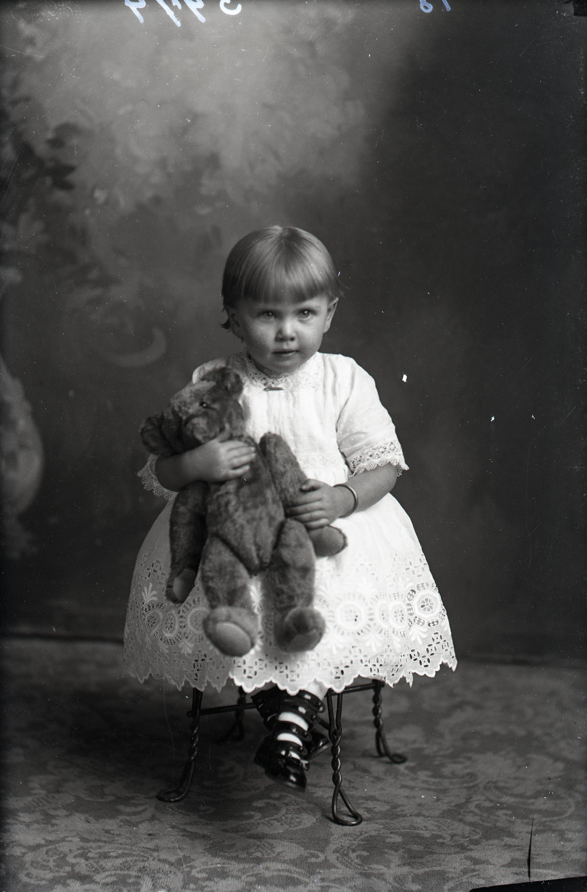 Toddler seated with bear