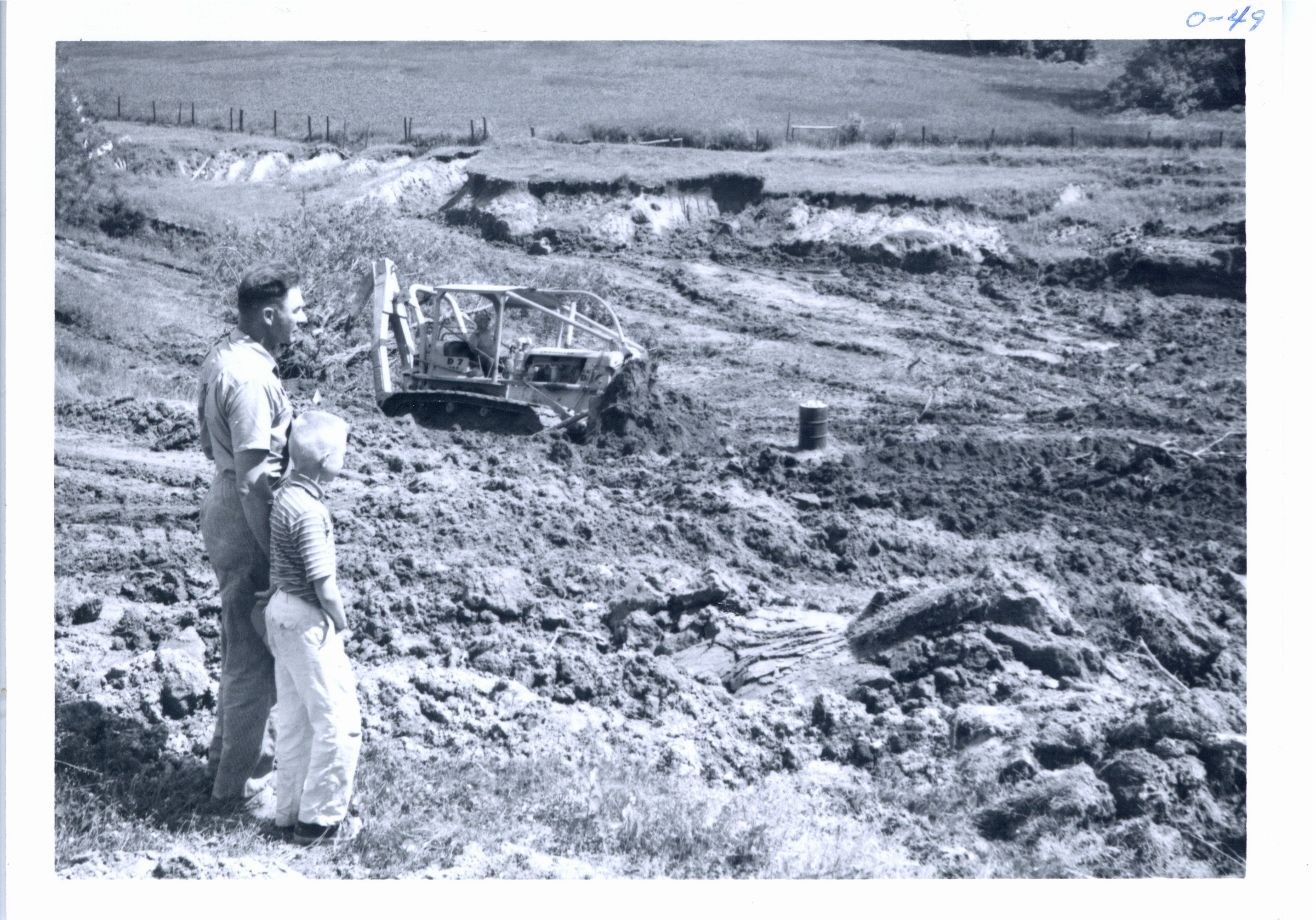 Clyde Small and son viewing pond construction, 1966