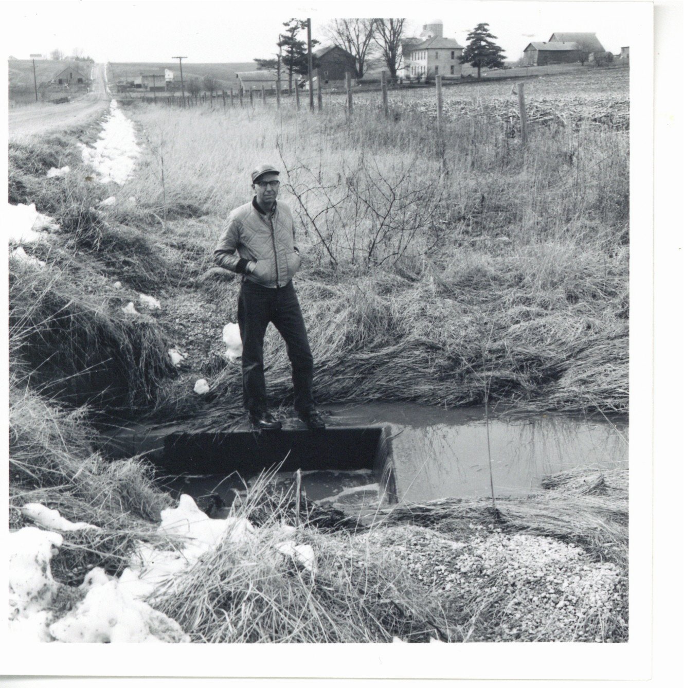 Harold Wilms standing on concrete box inlet, 1967