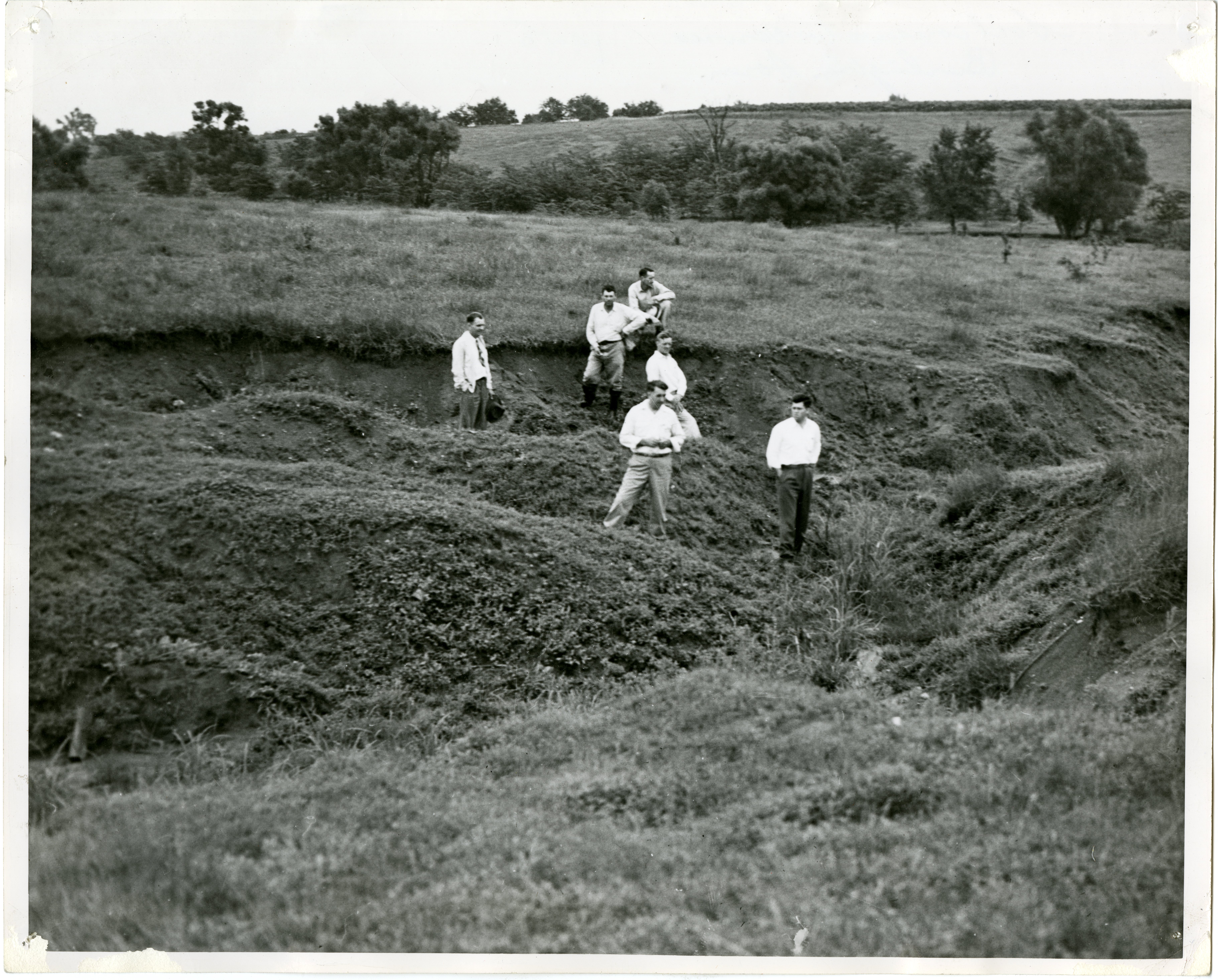 1948  Six Men Stand in Gullied Field