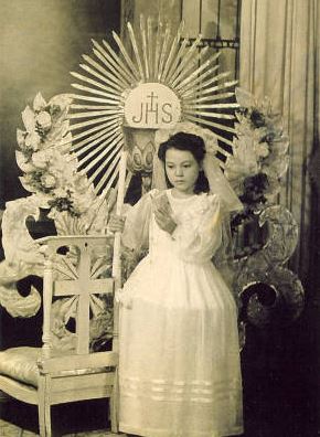 Title page; Girl in First Communion dress holding candle and prayer book, Holy City, Bettendorf, Iowa, 1920s<br />
