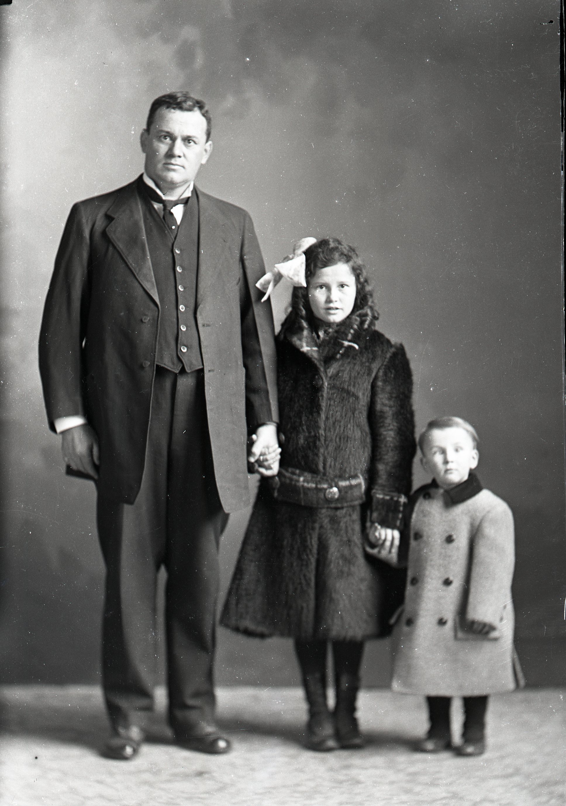 Man, girl and toddler in coats