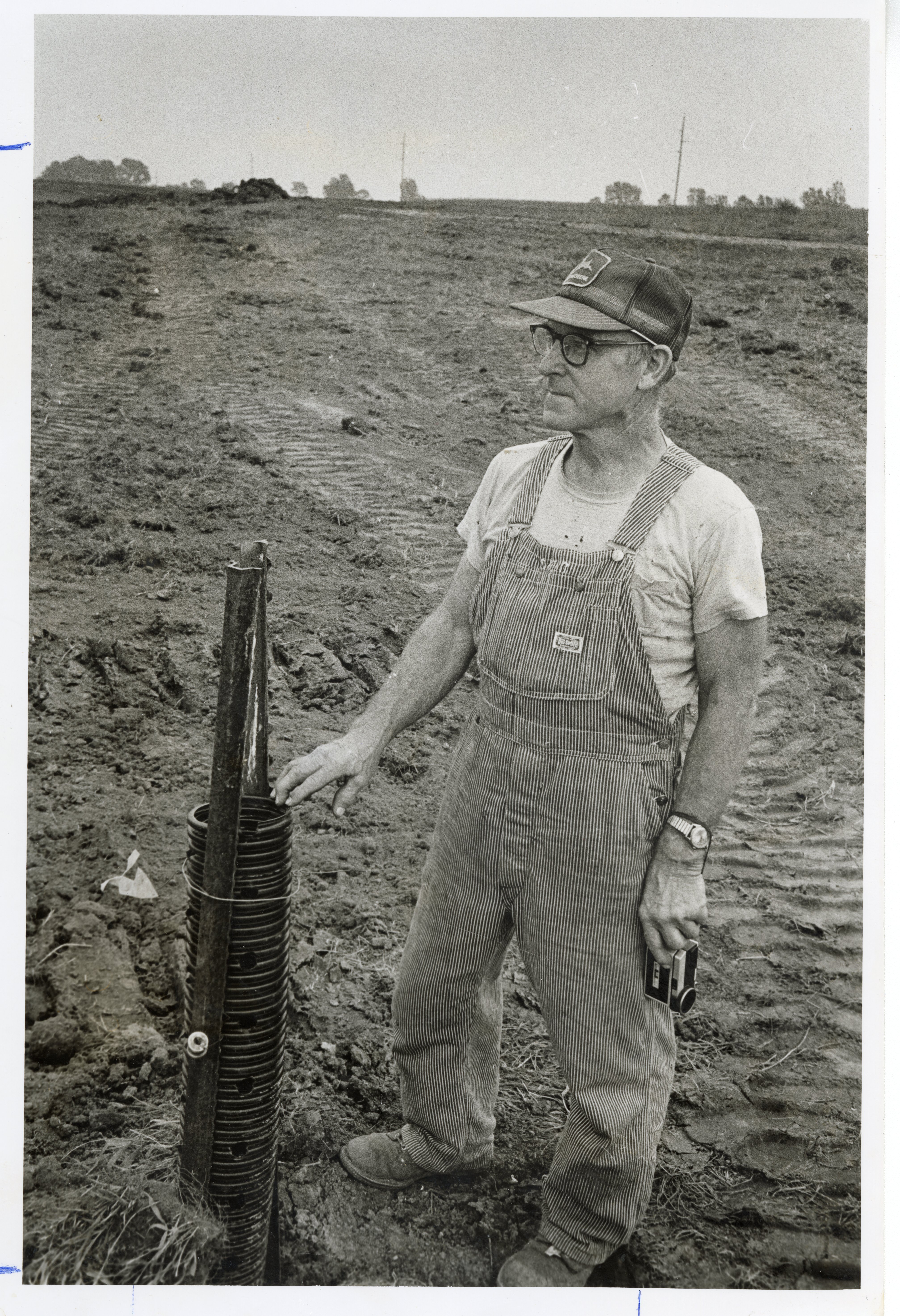 1977  Mr. Harris, a farmer, stands in field
