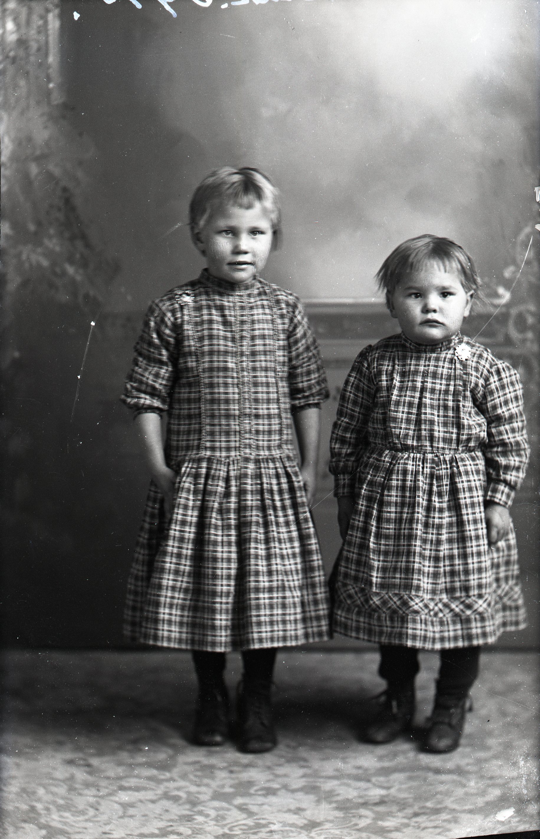 Two girls in plaid dresses