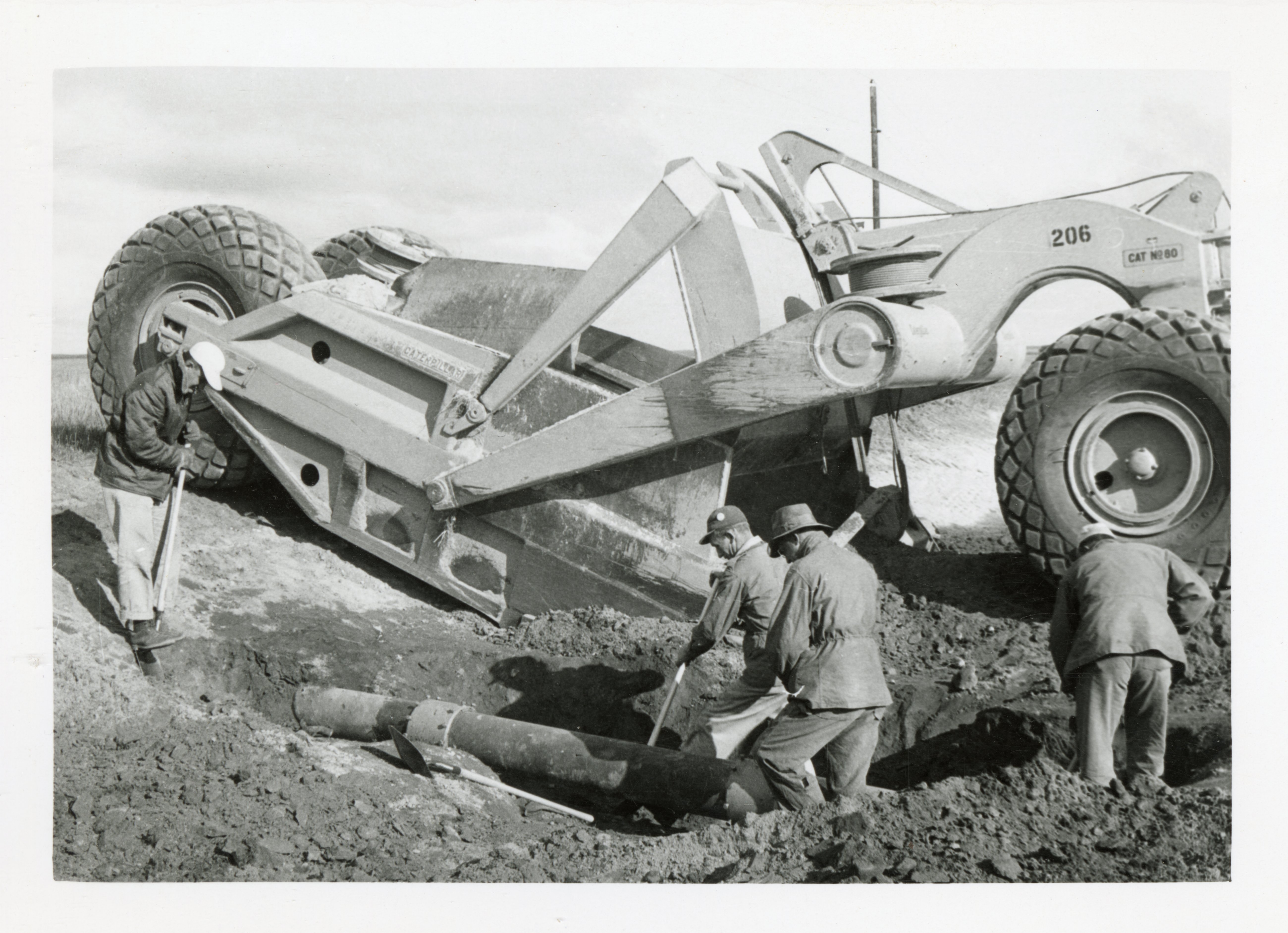 Earthmoving Scraper, Four Men and a Pipe