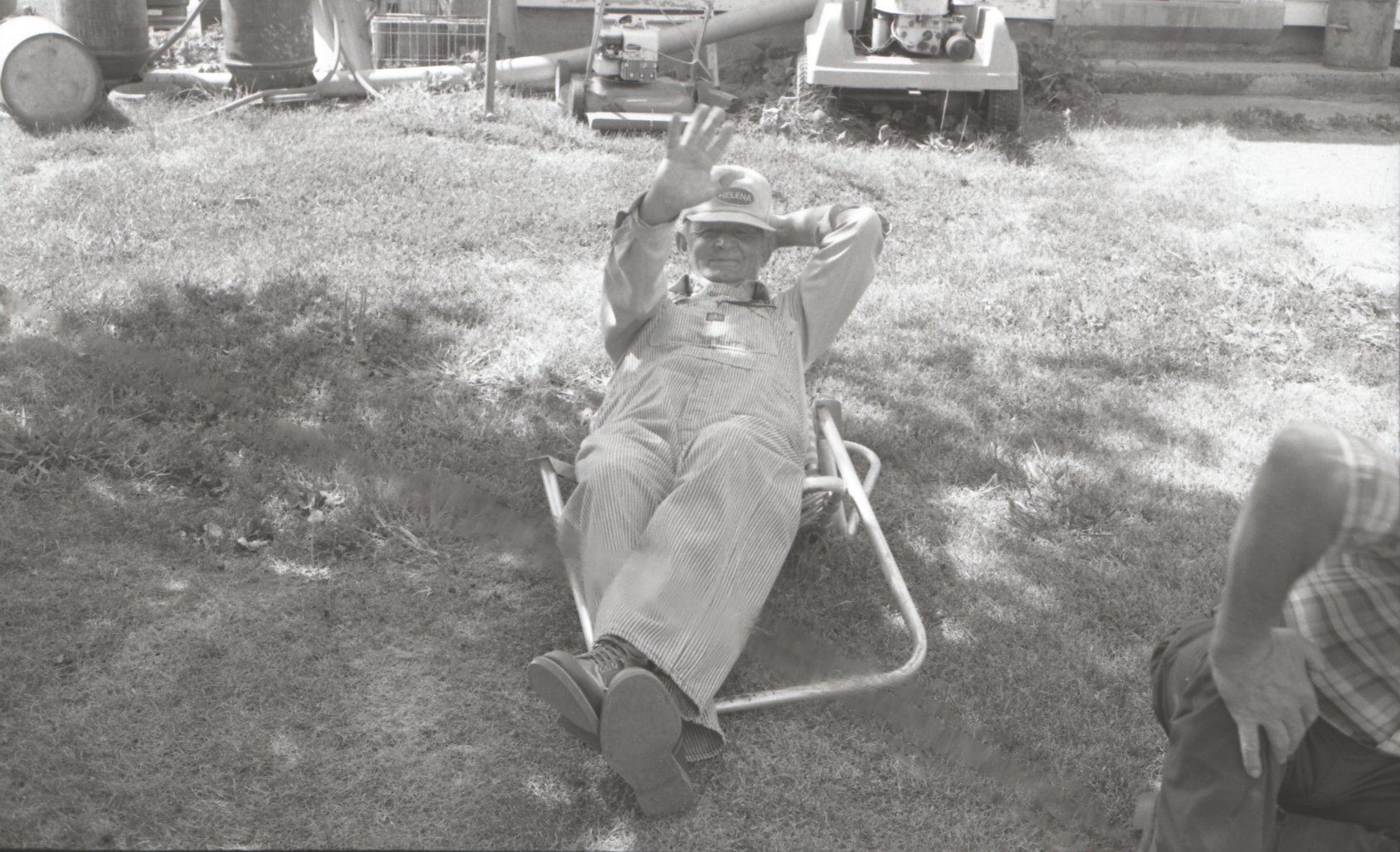 Waving farmer relaxes in chair