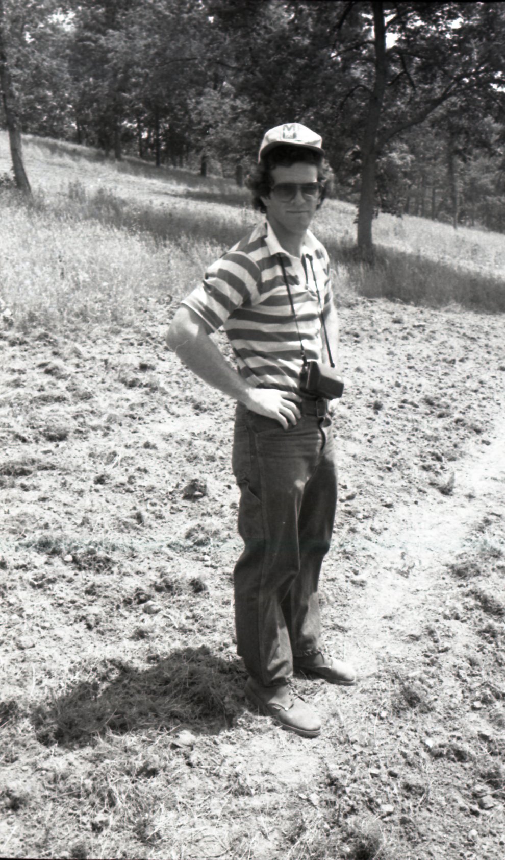 1978 Man stands in field by camera
