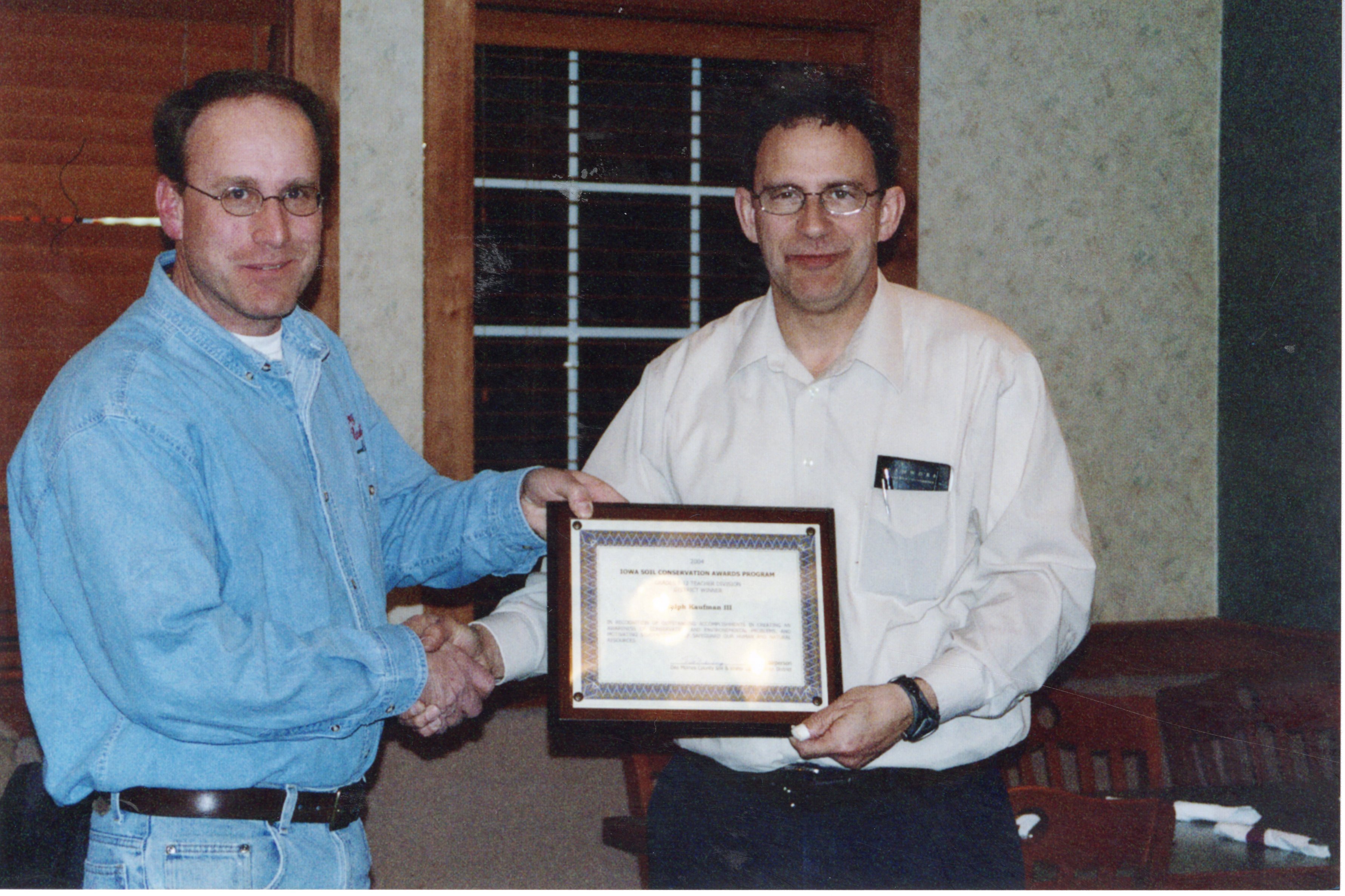 2004 Mediapolis teacher  Ralph Kauffman accepts Teacher of the Year conservation  award from Chairperson Todd Heckenberg 