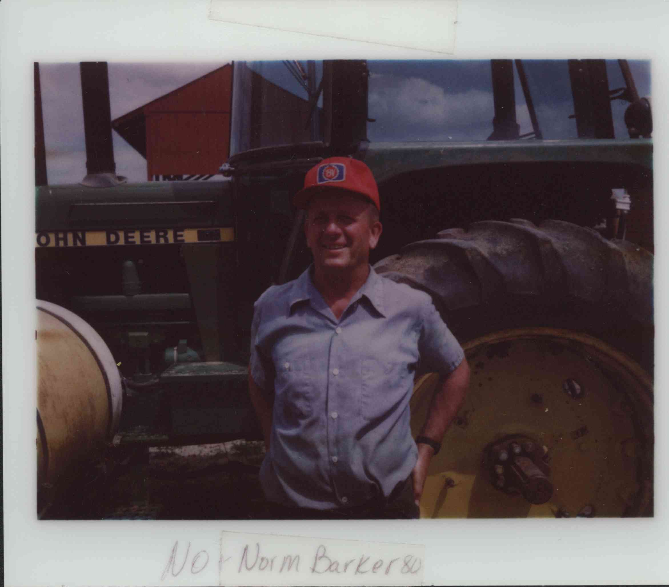 Norm Barker Standing in Front of John Deere Tractor