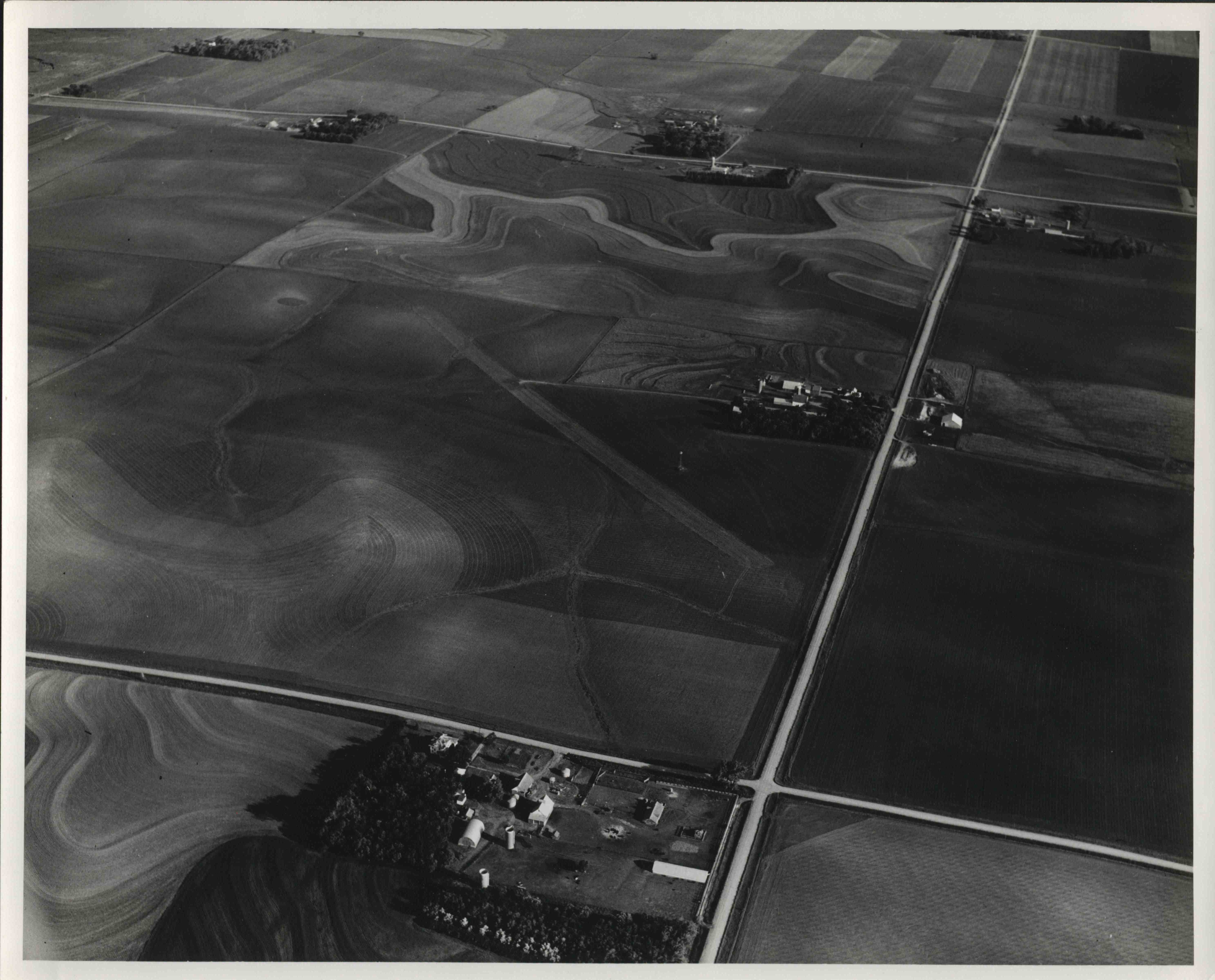 Aerial view of contoured farmland showing roads and farms