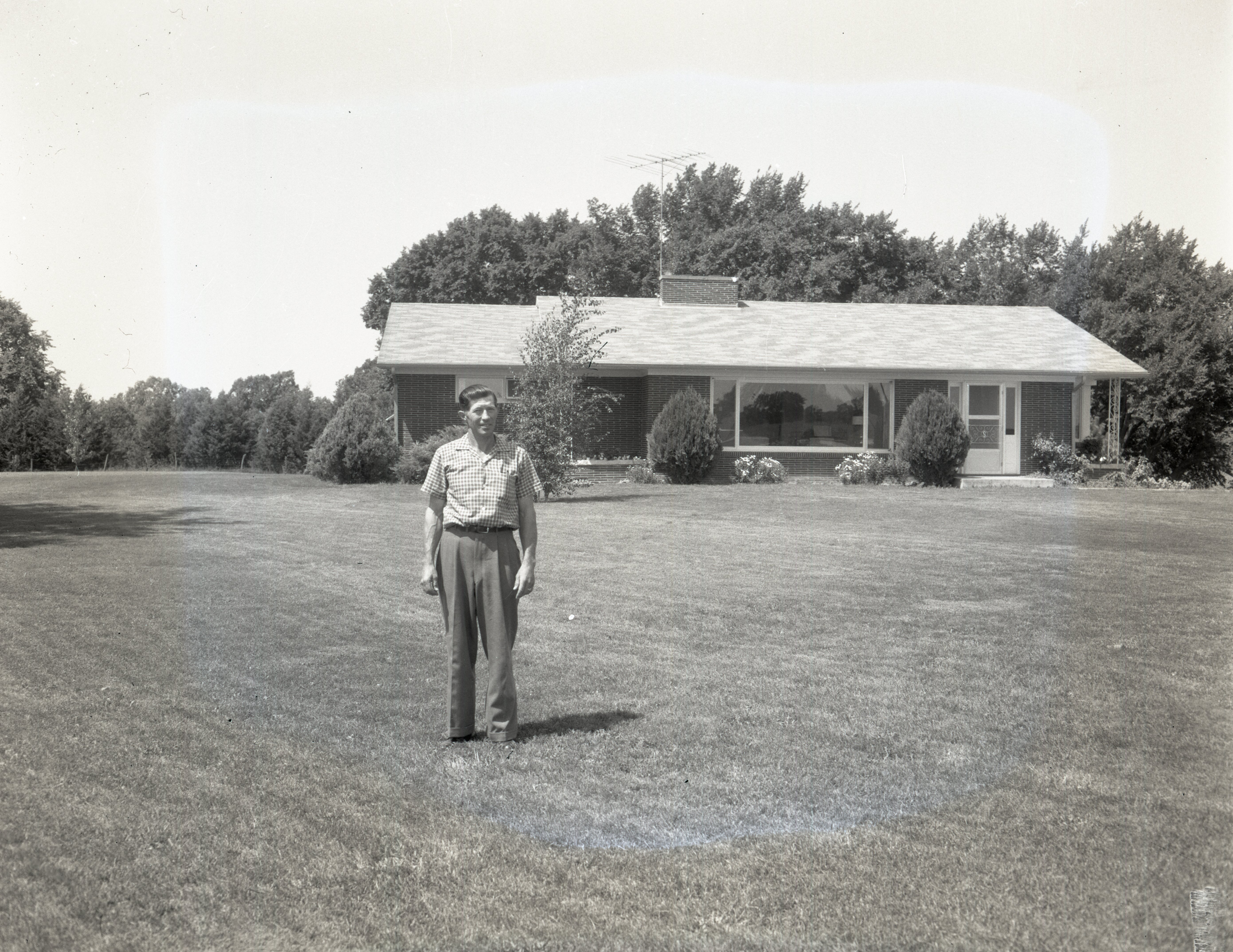 Man stands in front of ranch style house