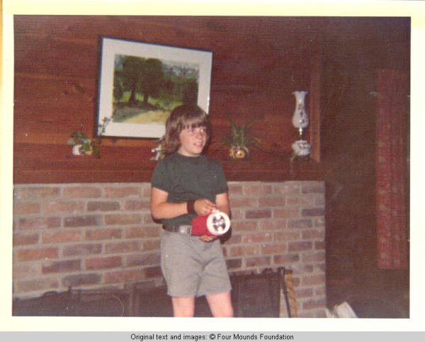John, Jr. standing by fire place with flash light