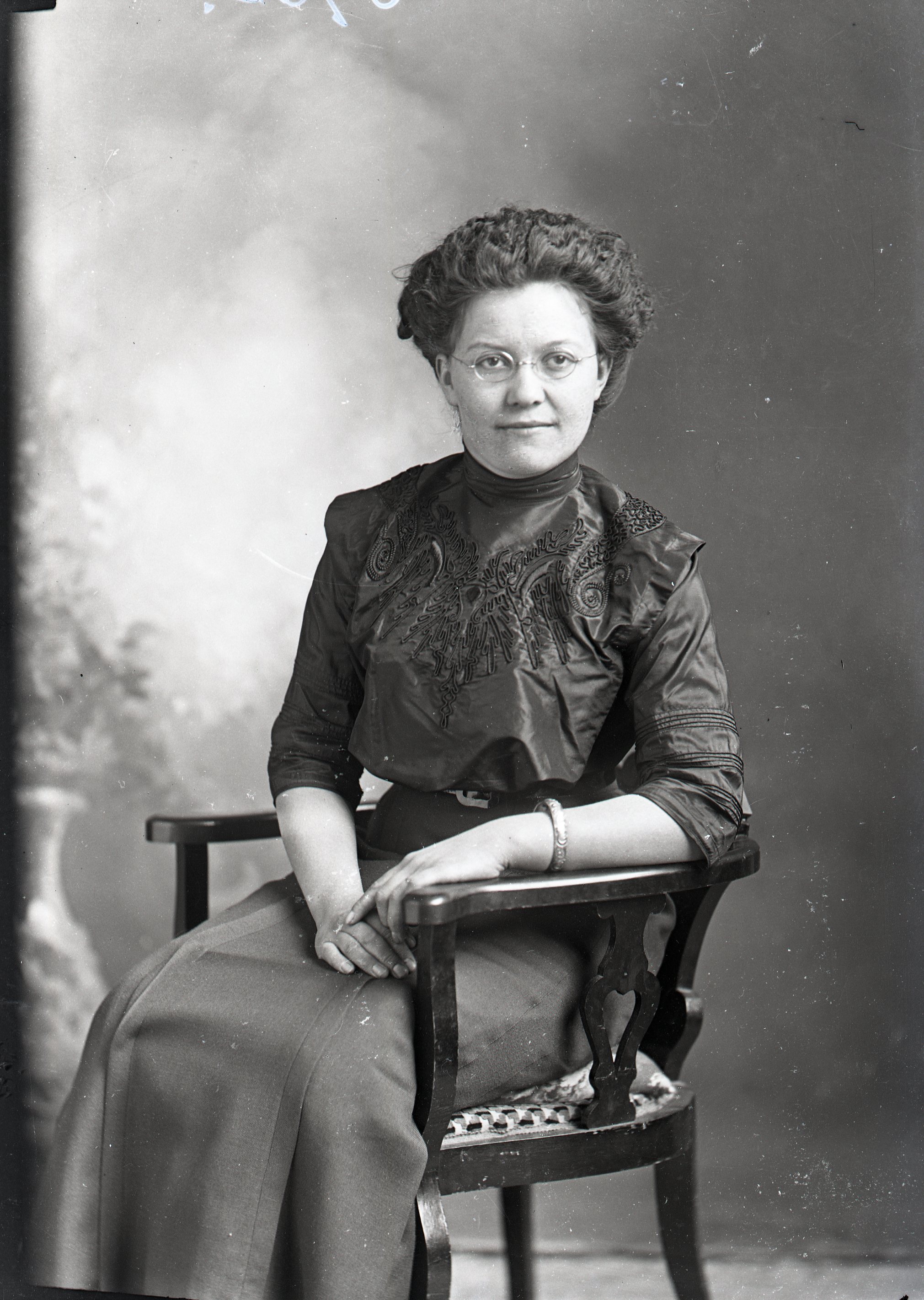 Woman with glasses, seated