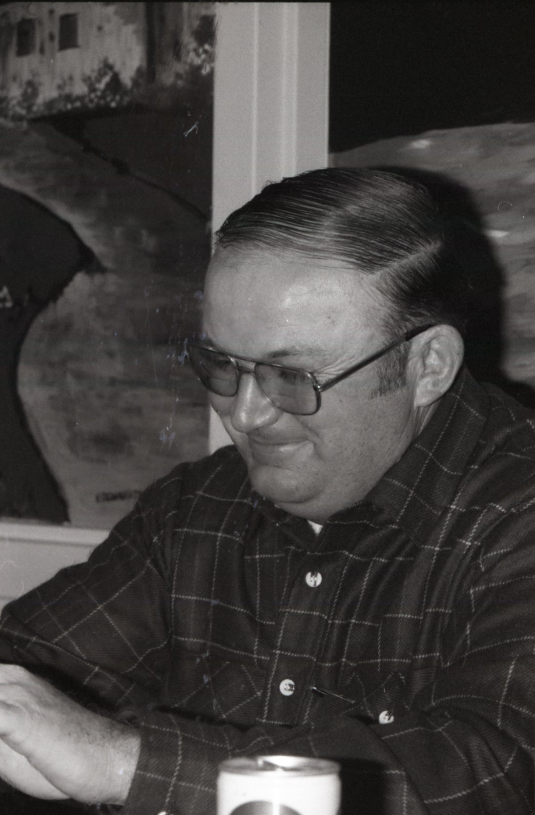 Smiling man in glasses looks down