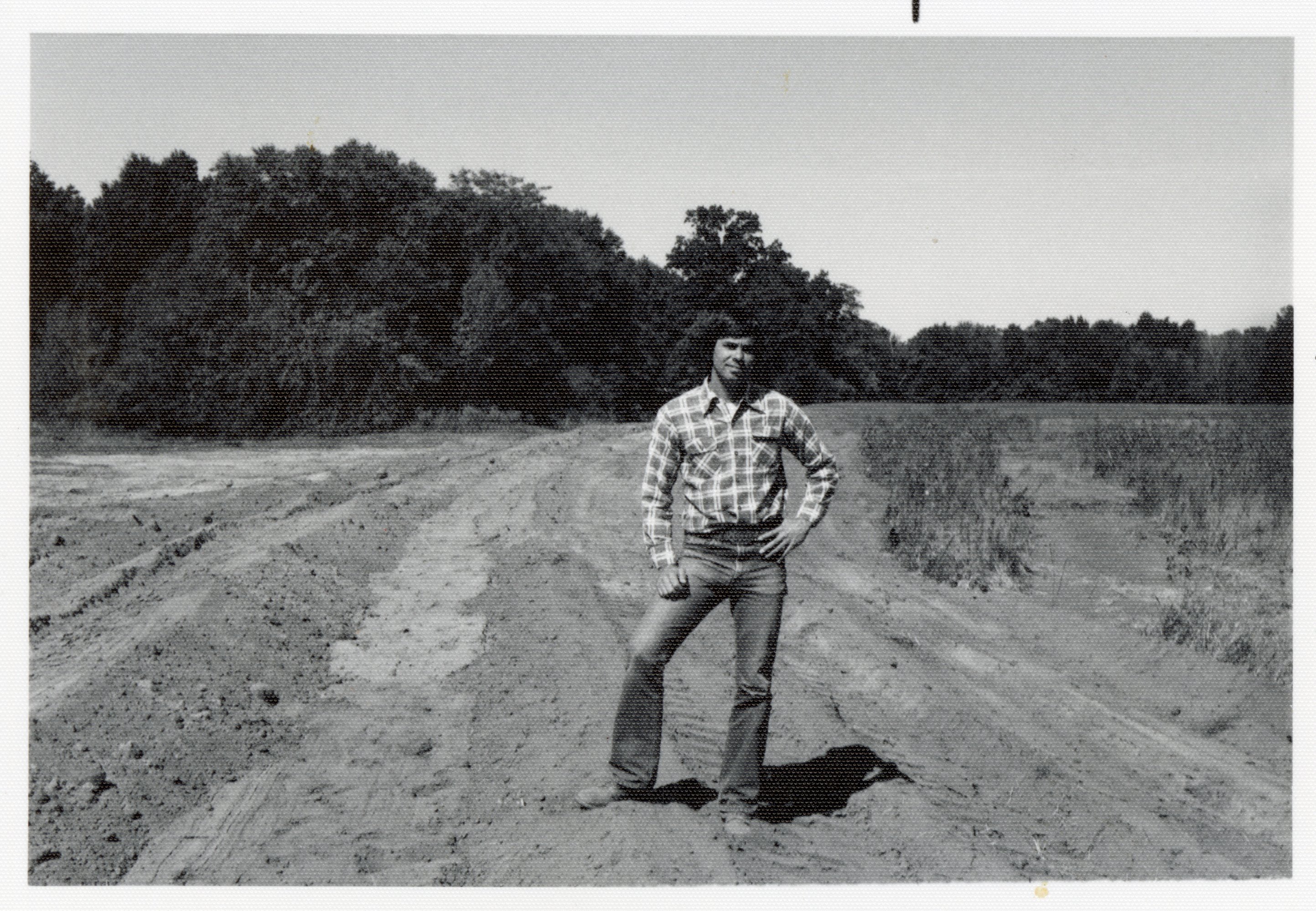 1977 Howard Bright stands in field