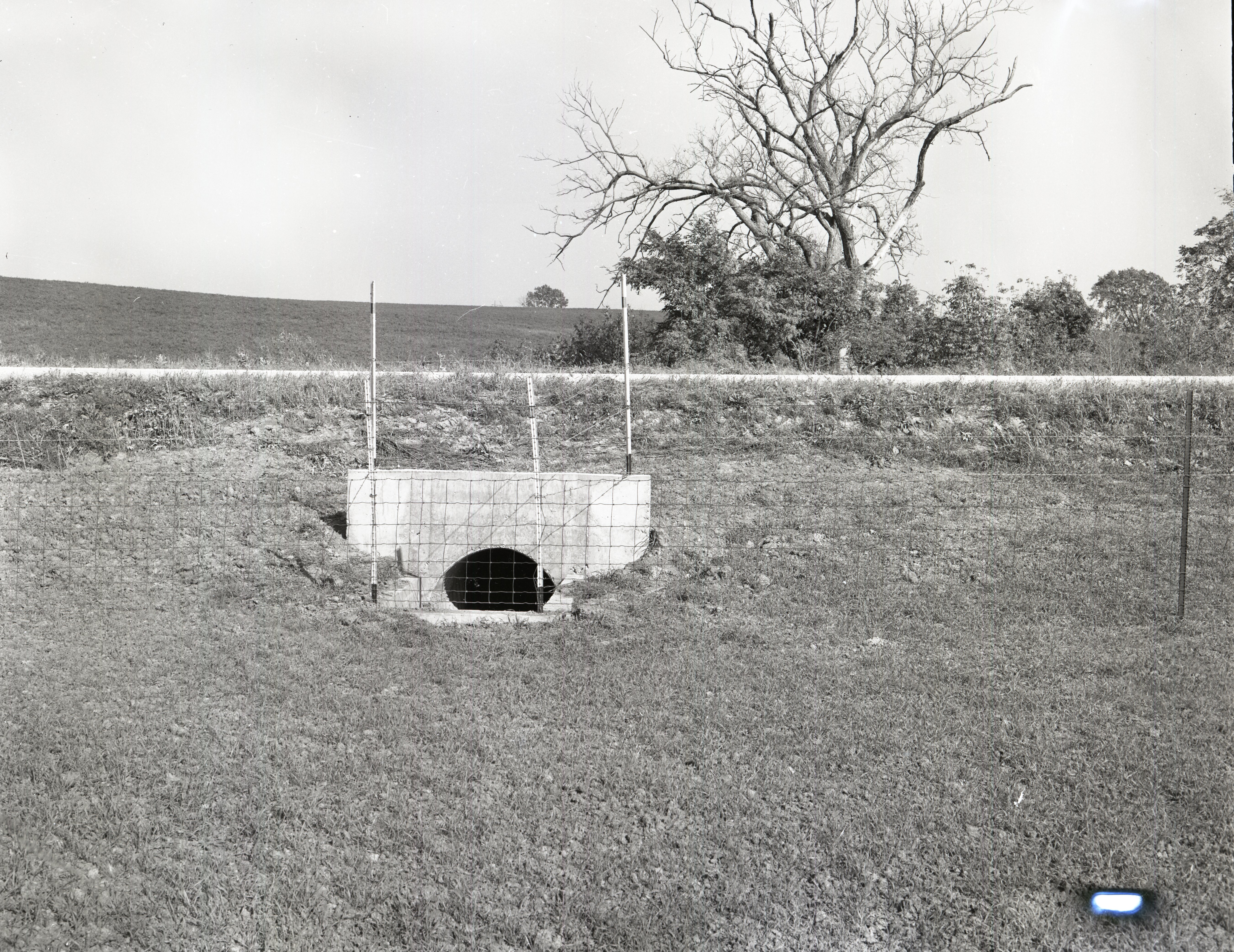 Water culvert with fence by road