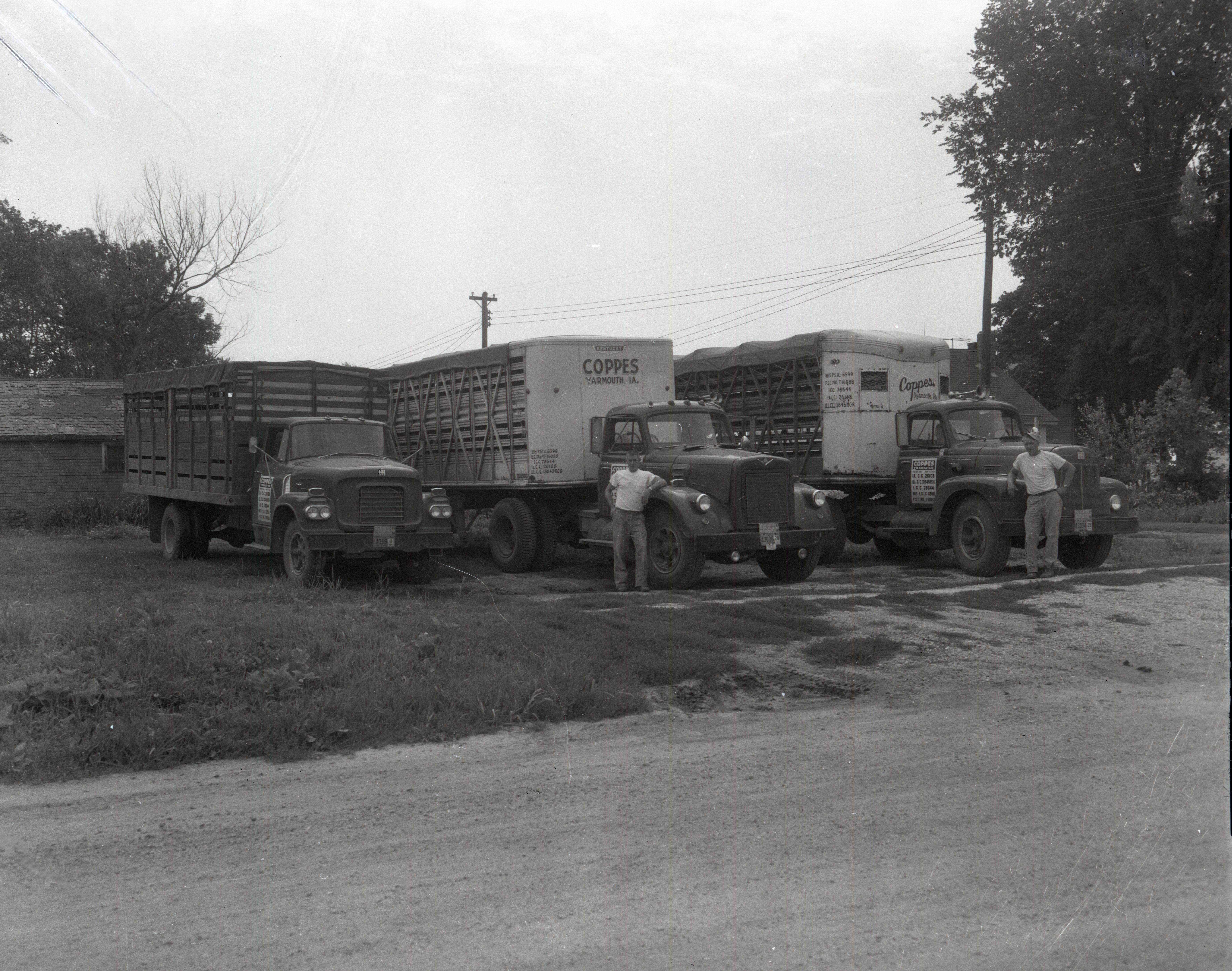 Three trucks with two men standing by them