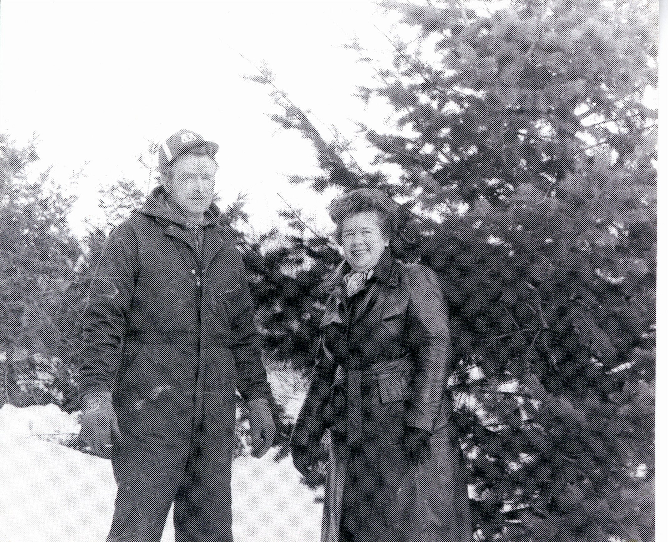 Unidentified man and woman standing near evergreen tree