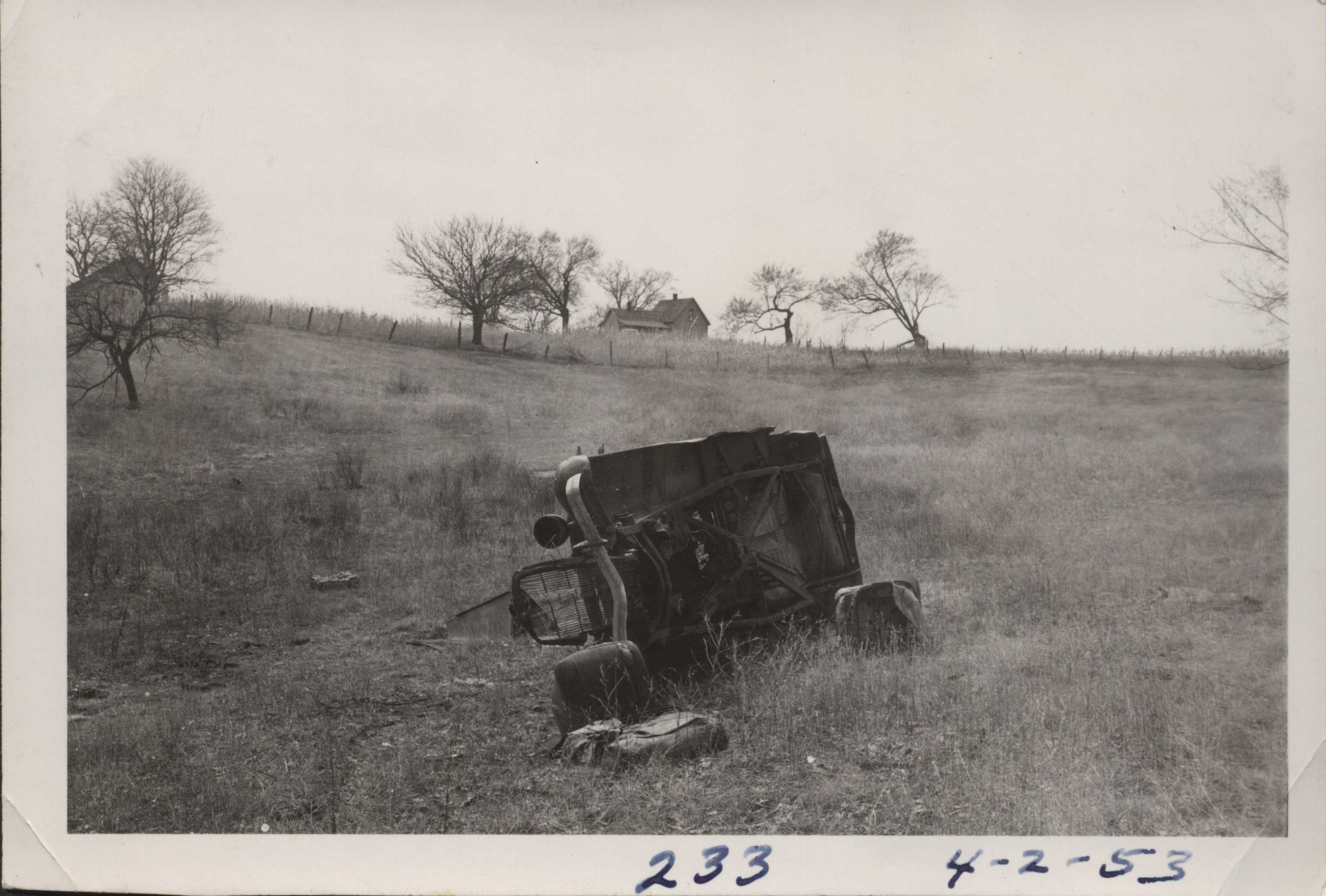 Wrecked car in a field.