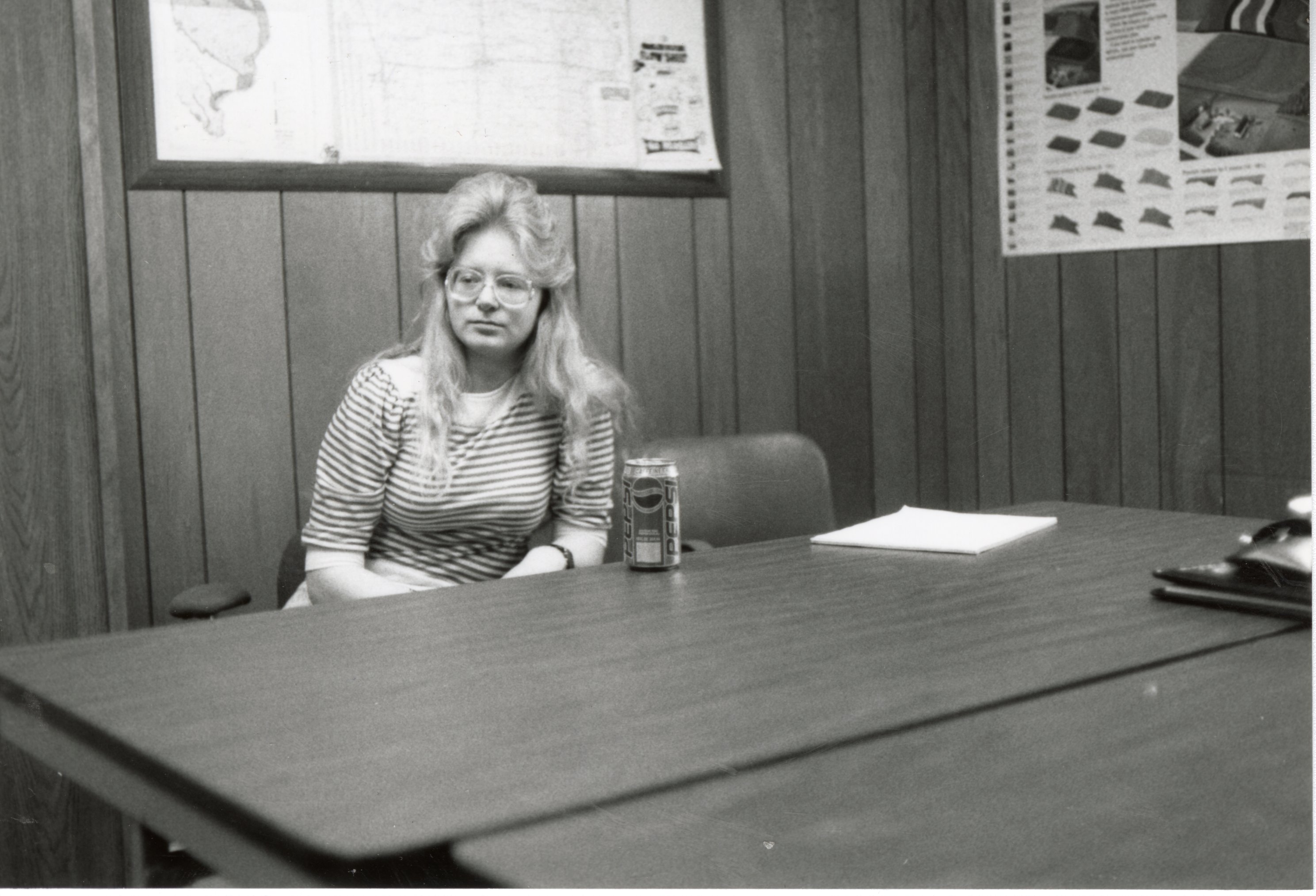 Penny Williams, Volunteer, sits at a table in an office