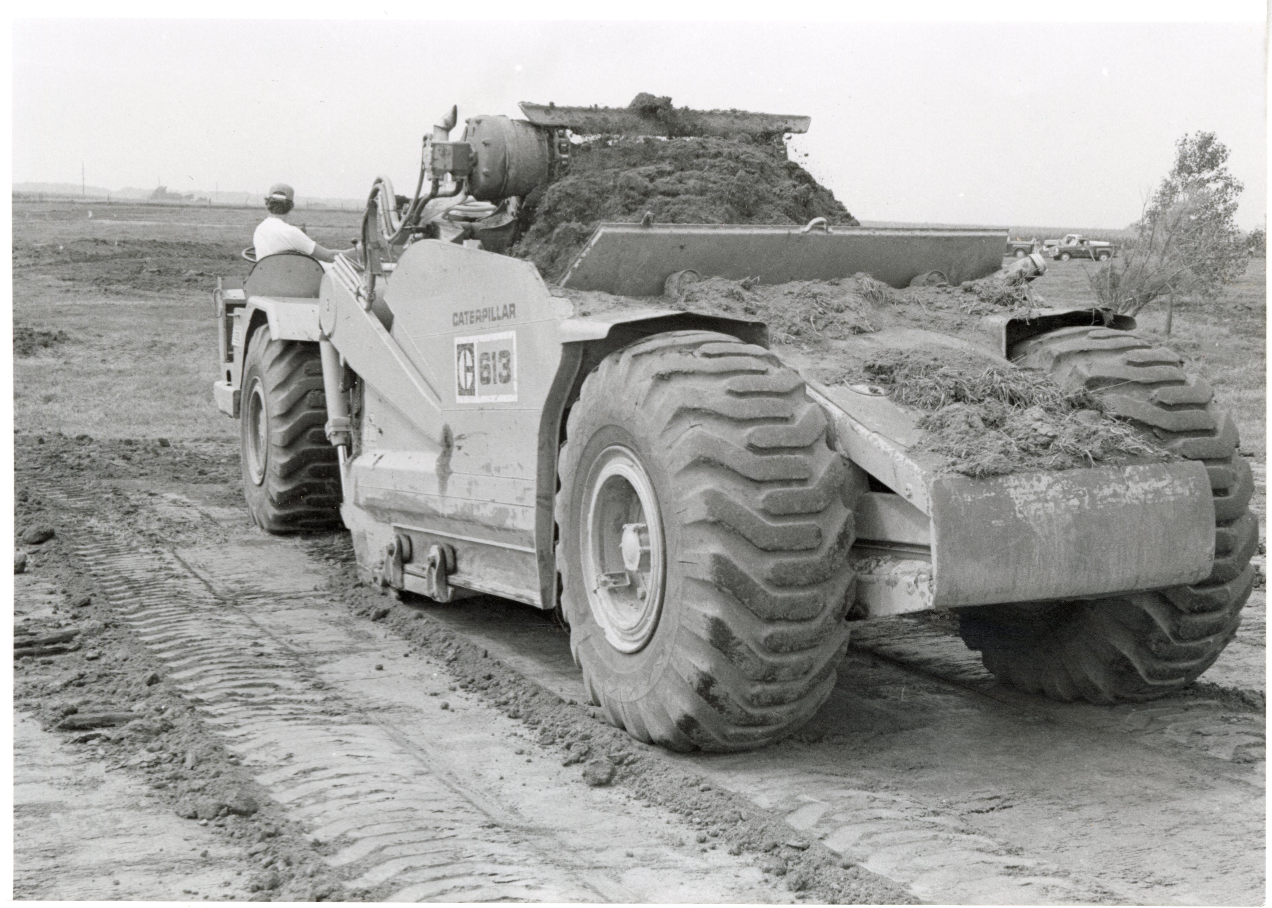 1979  Back view of Caterpillar 613 earthmoving machine filled with dirt