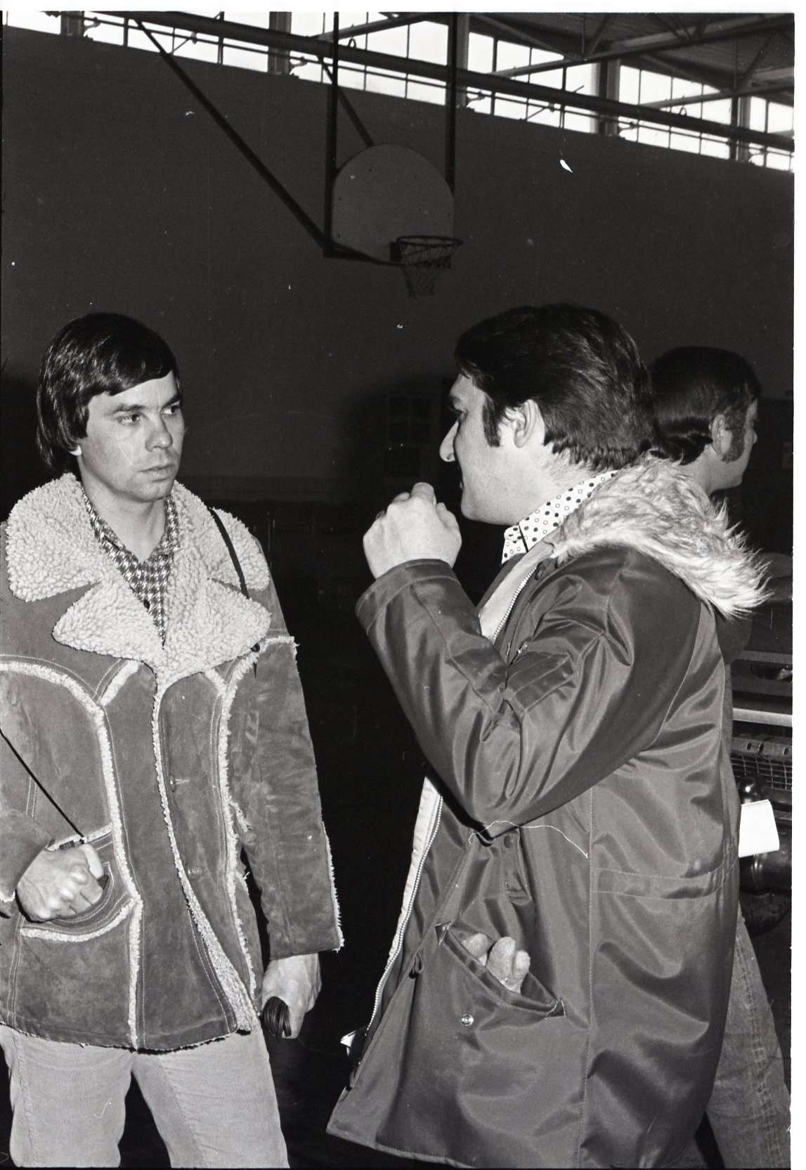 Howard Bright and another man talk in gym