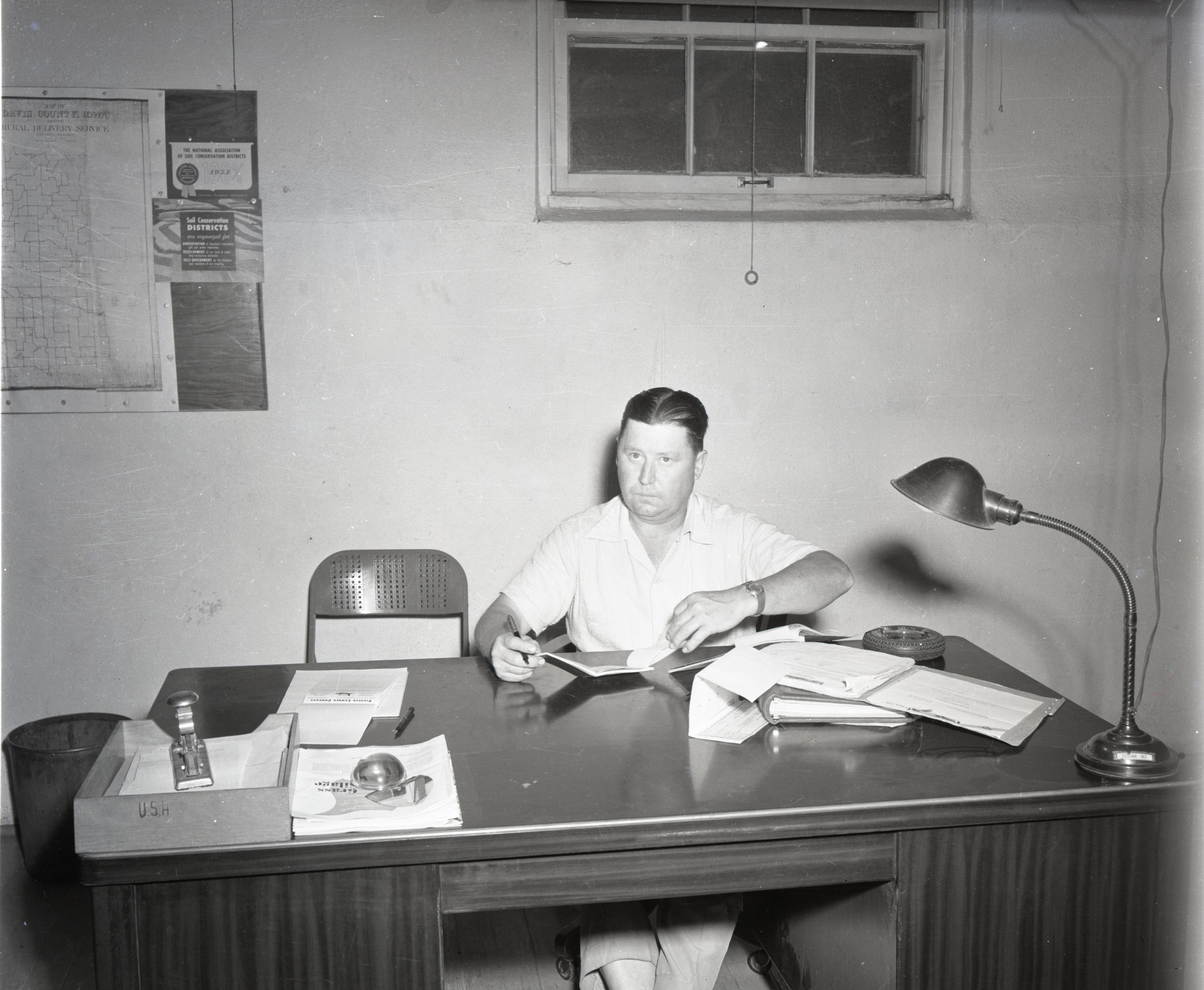 Unidentified Man Sits at Desk in Office