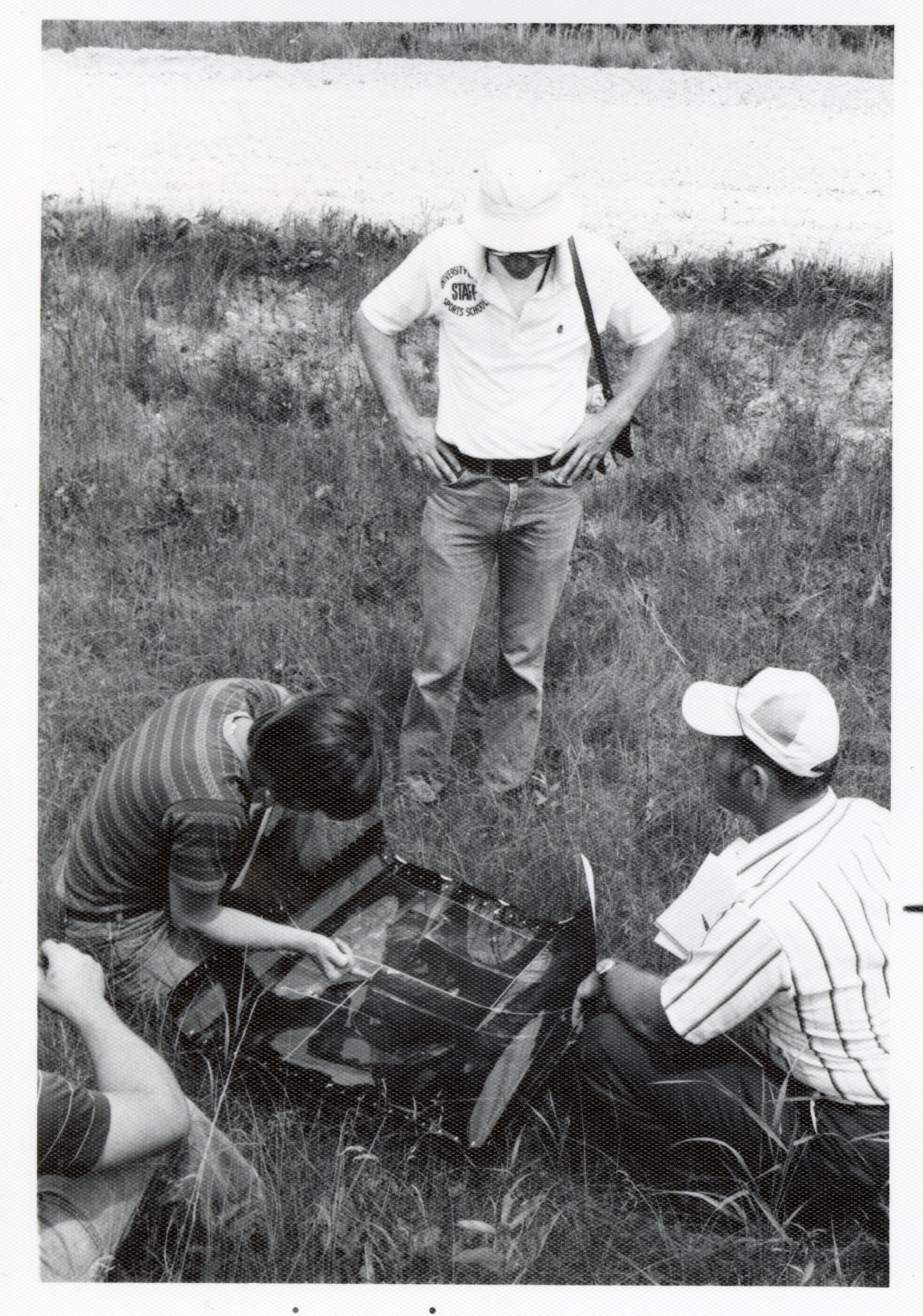 Three men study aerial photos