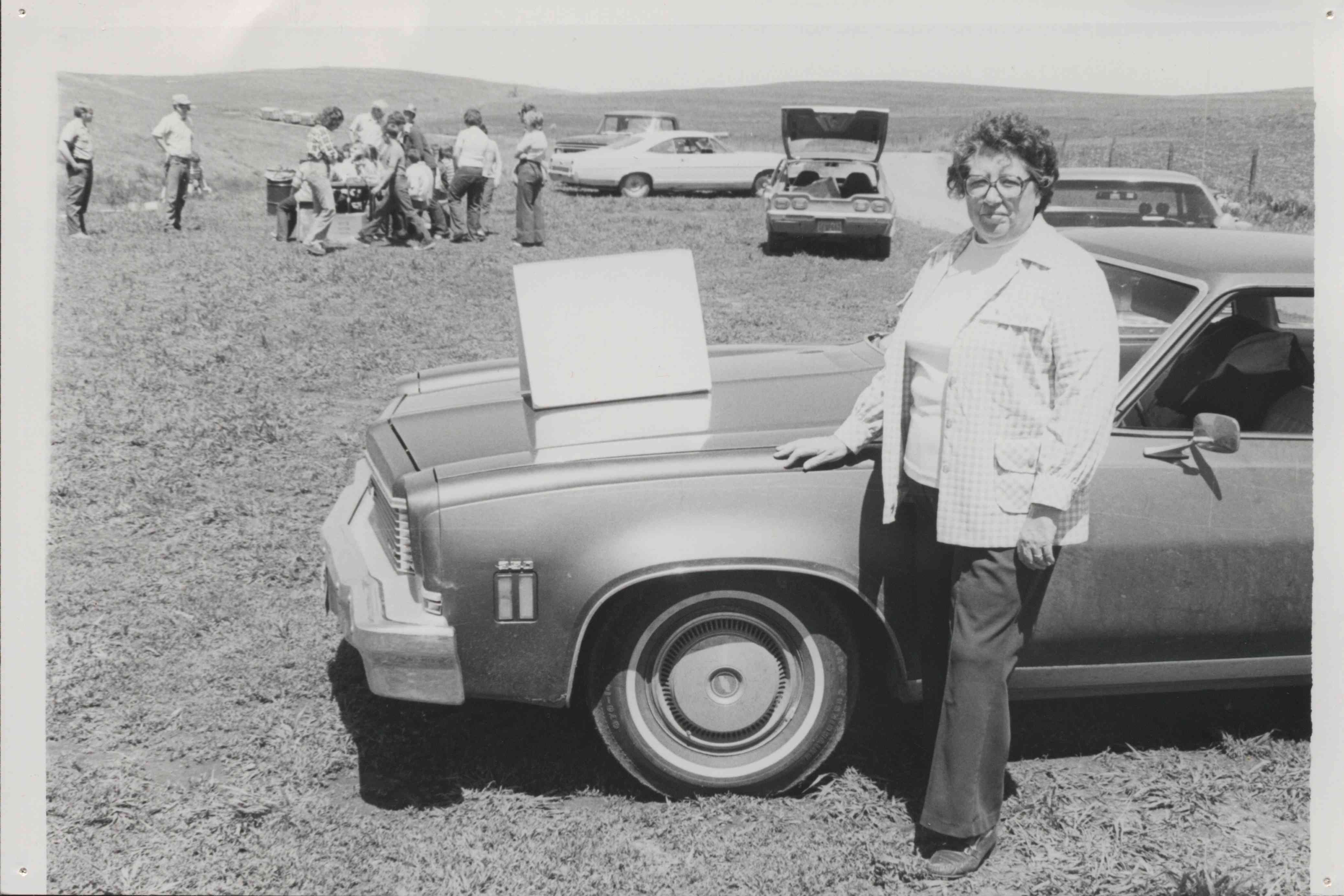 Woman Standing with Hand on Front of Car