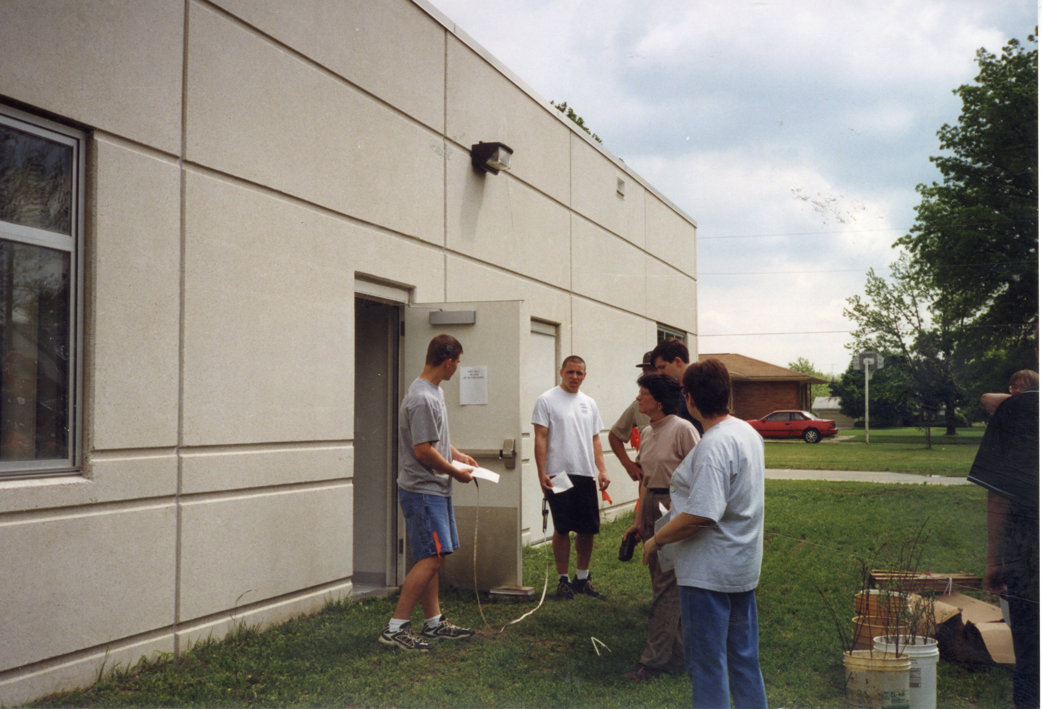 1999 Students Marc Gorsch and Mike Pope prepare to plant a tree while other students and teachers watch